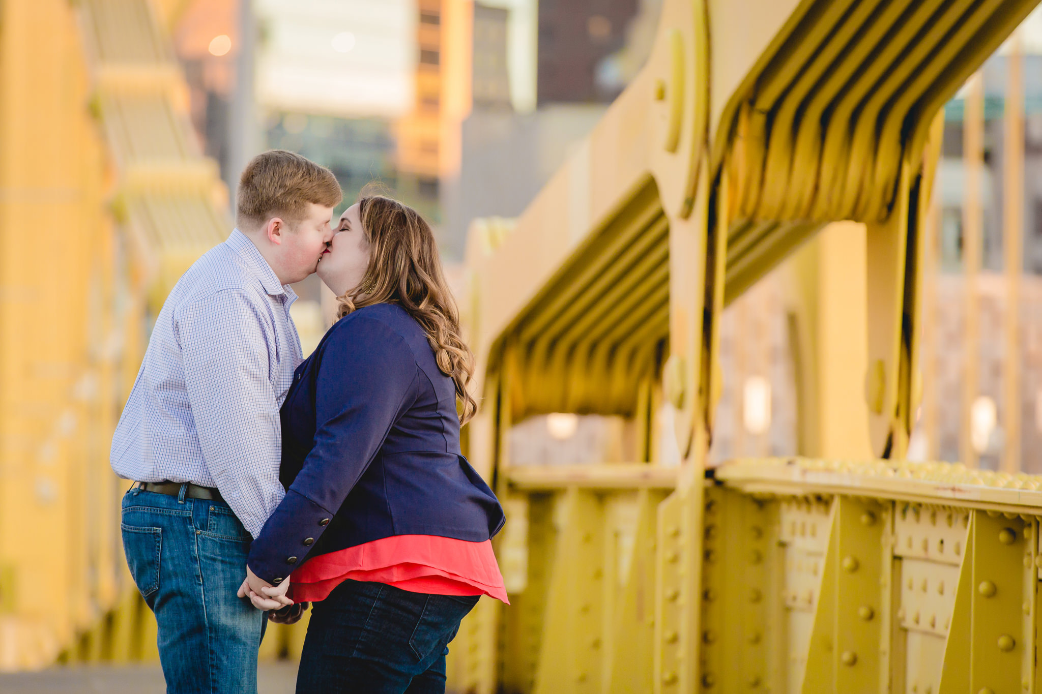 Engaged couple kissing on the Roberto Clemente Bridge