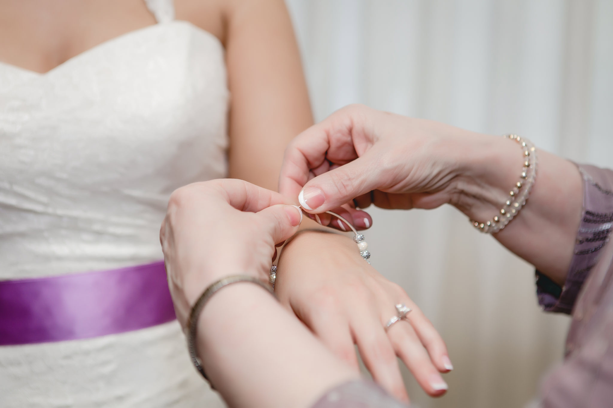 Mother of the bride putting a bracelet on the bride's wrist