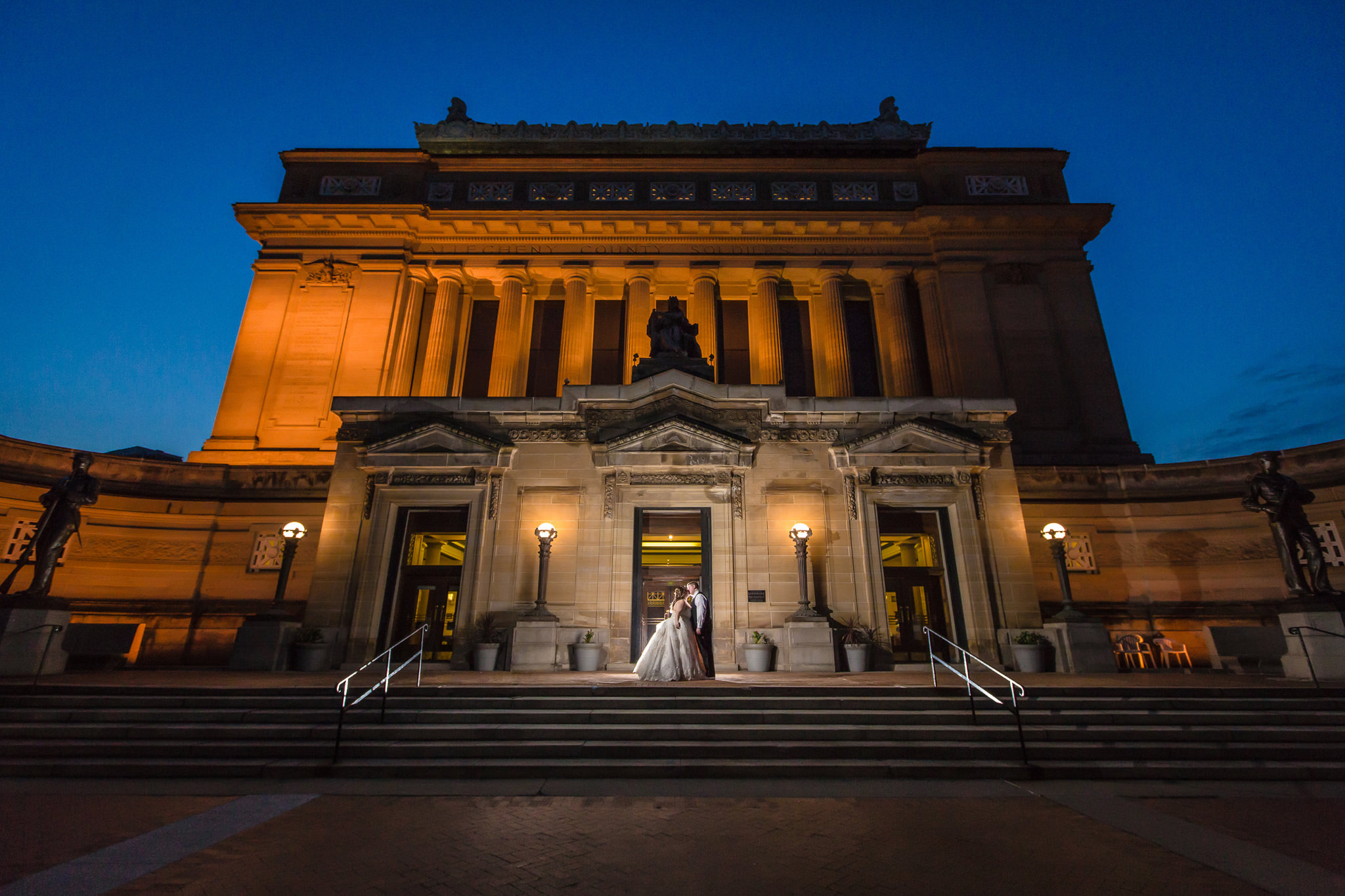 Bride and groom kiss in front of Soldiers & Sailors Memorial Hall