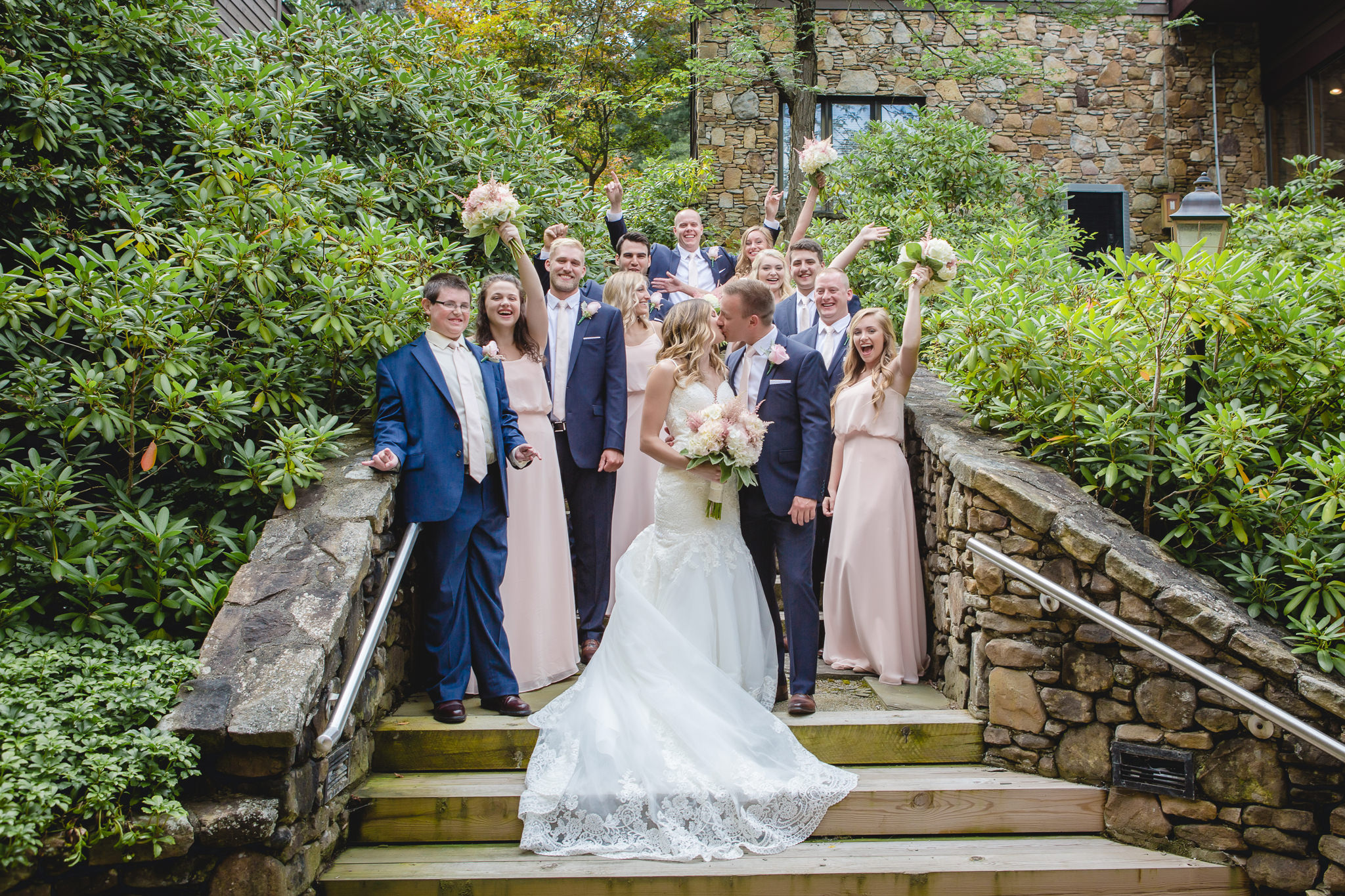 Bridal party cheers the bride and groom as they kiss at Hidden Valley Resort