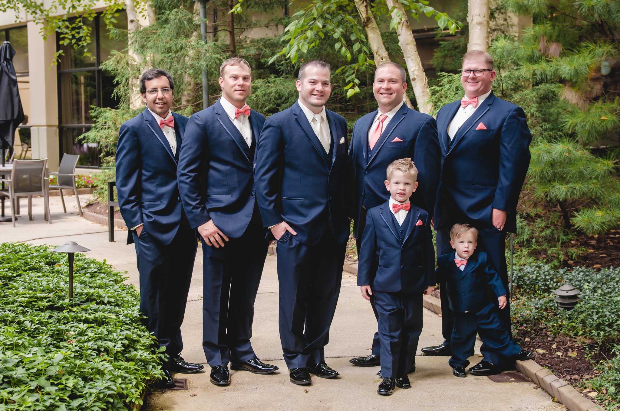 Groom poses with his groomsmen and ring bearers in the courtyard of the Pittsburgh Airport Marriott