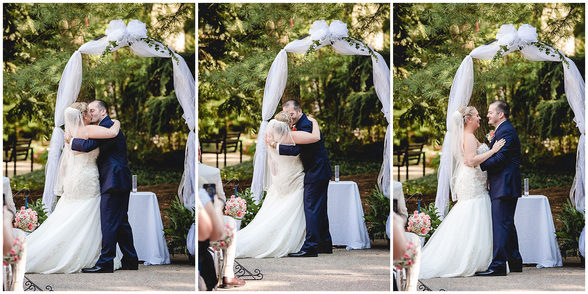 Bride and groom share a first kiss at their outdoor wedding ceremony