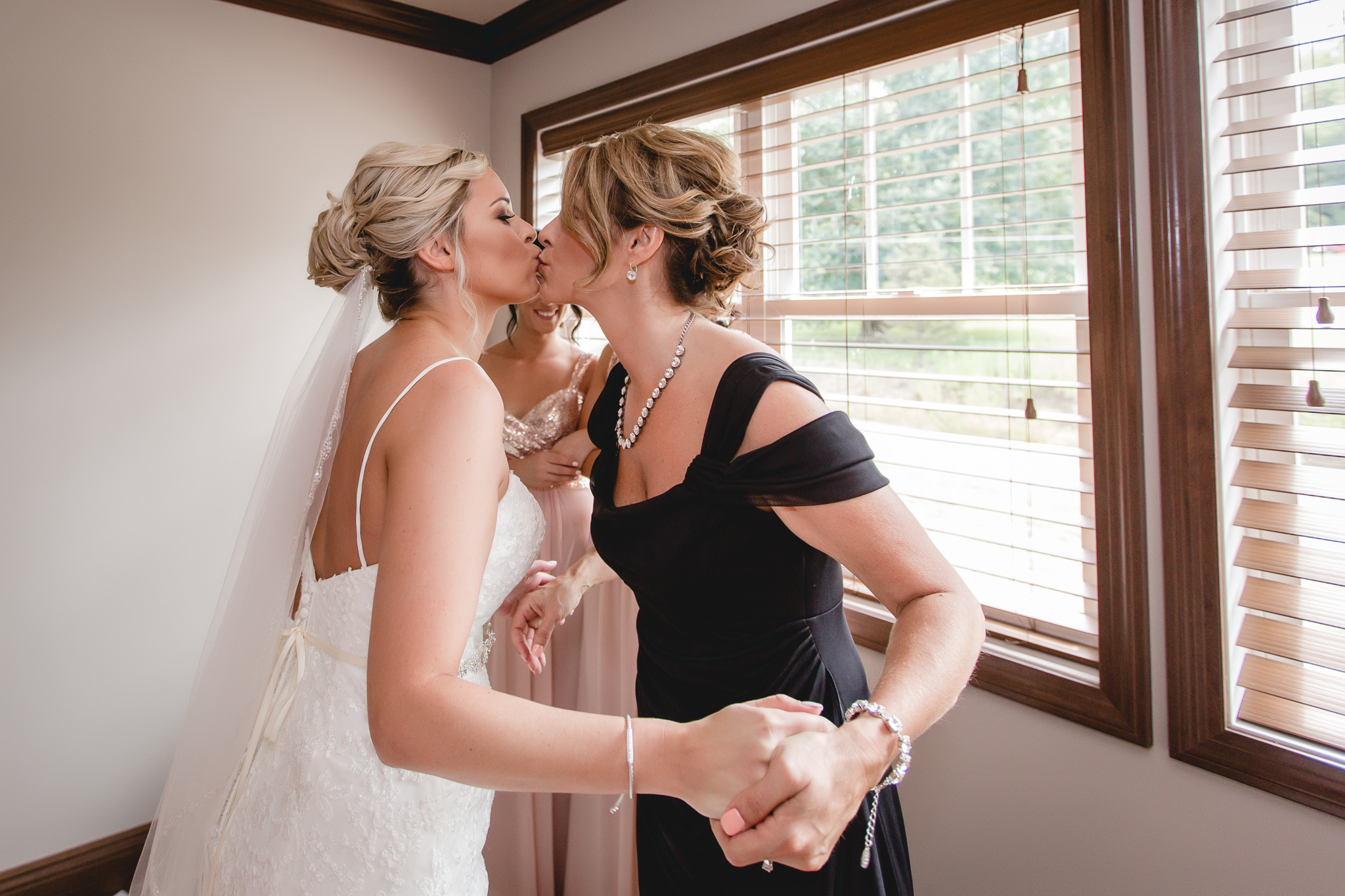 Mother of the bride kisses her daughter before her Gathering Place at Darlington Lake wedding