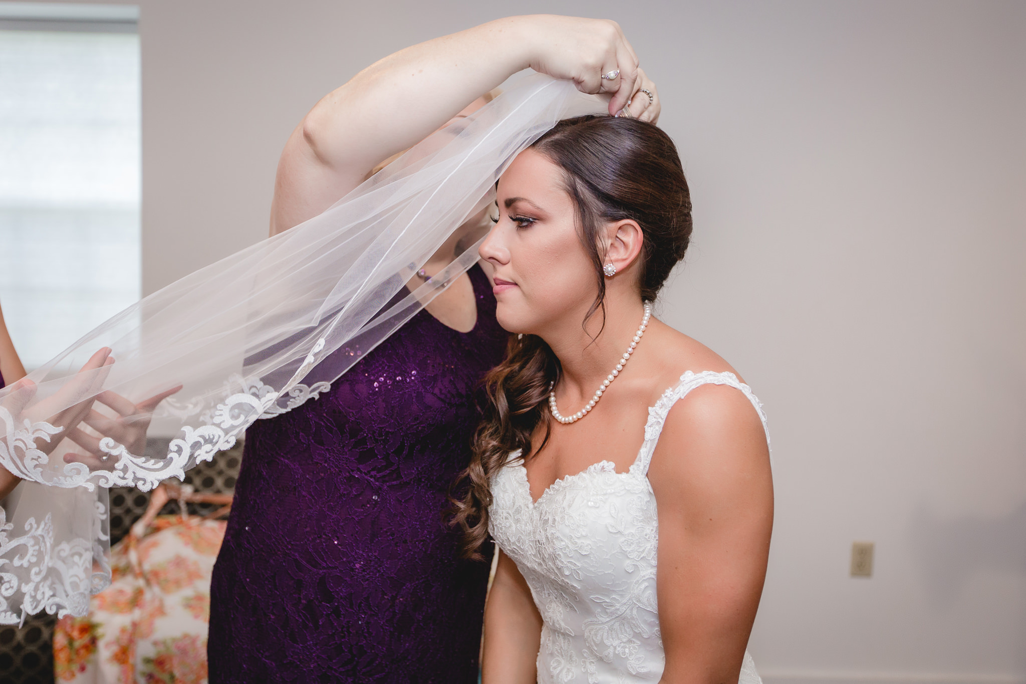 Mother of the bride helps with the veil at a White Barn wedding