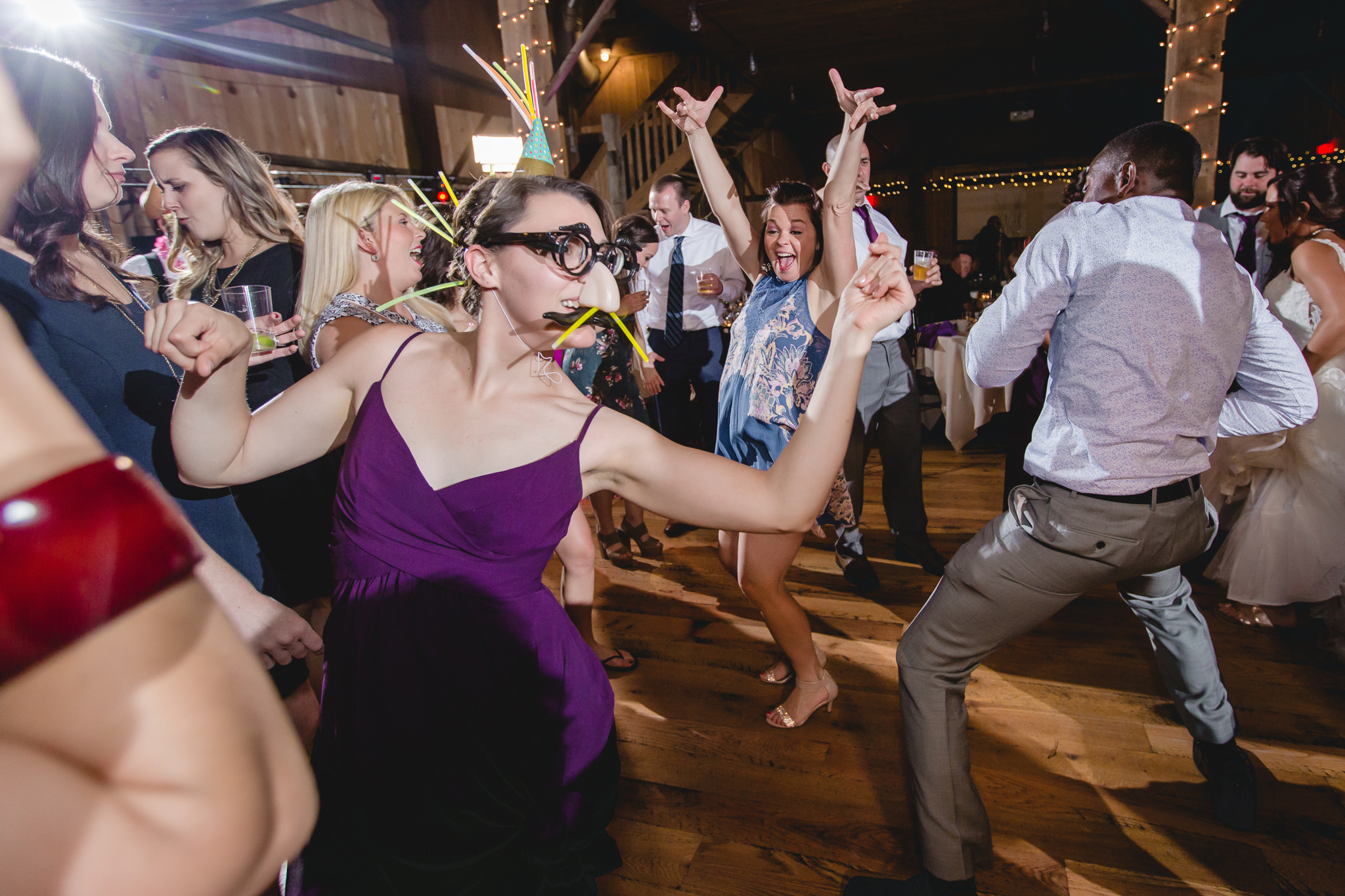 Bridesmaid wears DJ props on the dance floor at White Barn