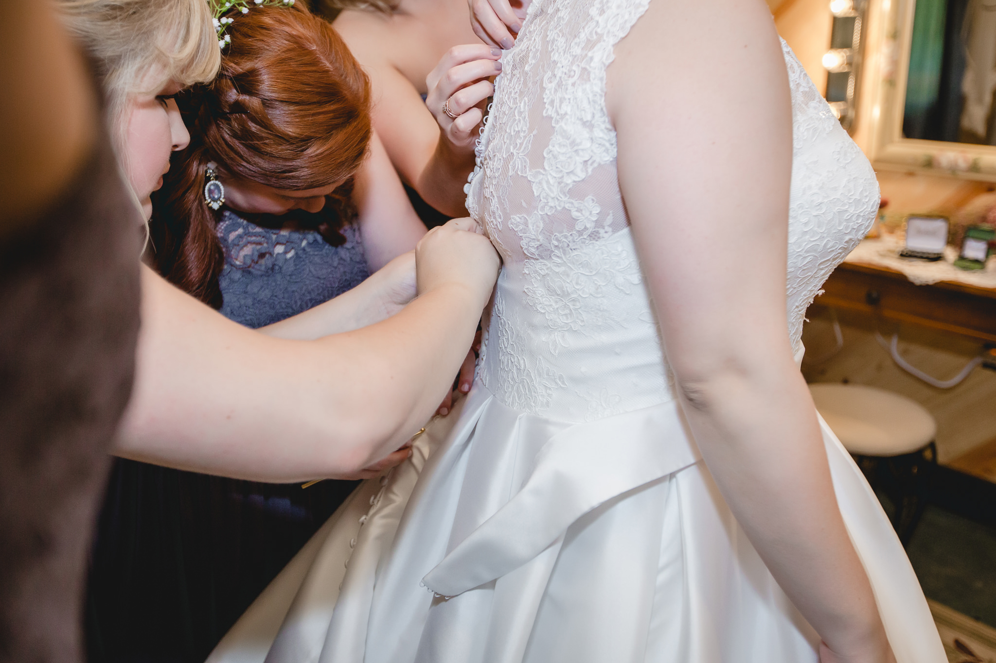 Bridesmaids button the back of the bride's Essense of Australia wedding dress