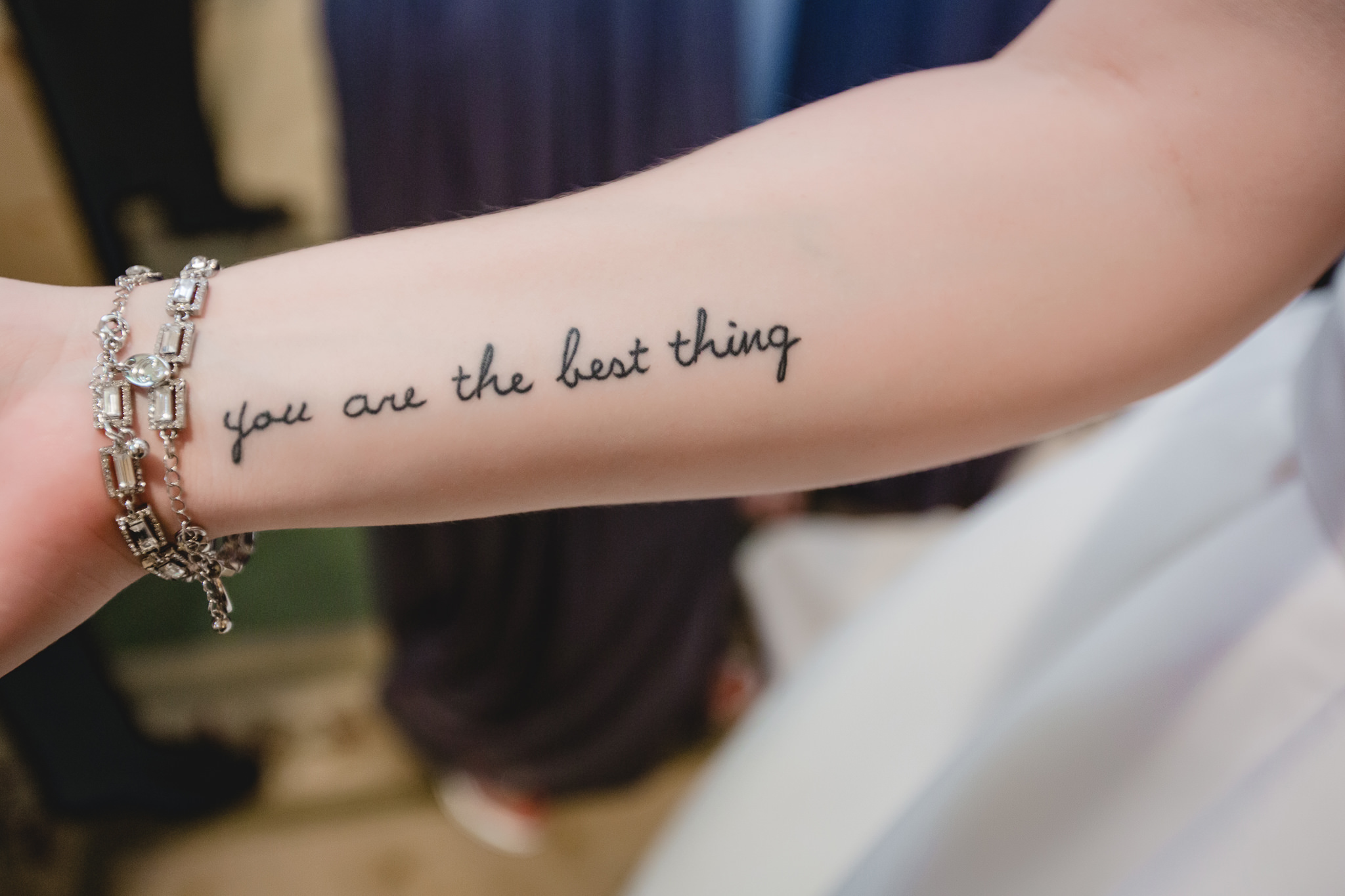 Bride's forearm tattoo says "You are the best thing"