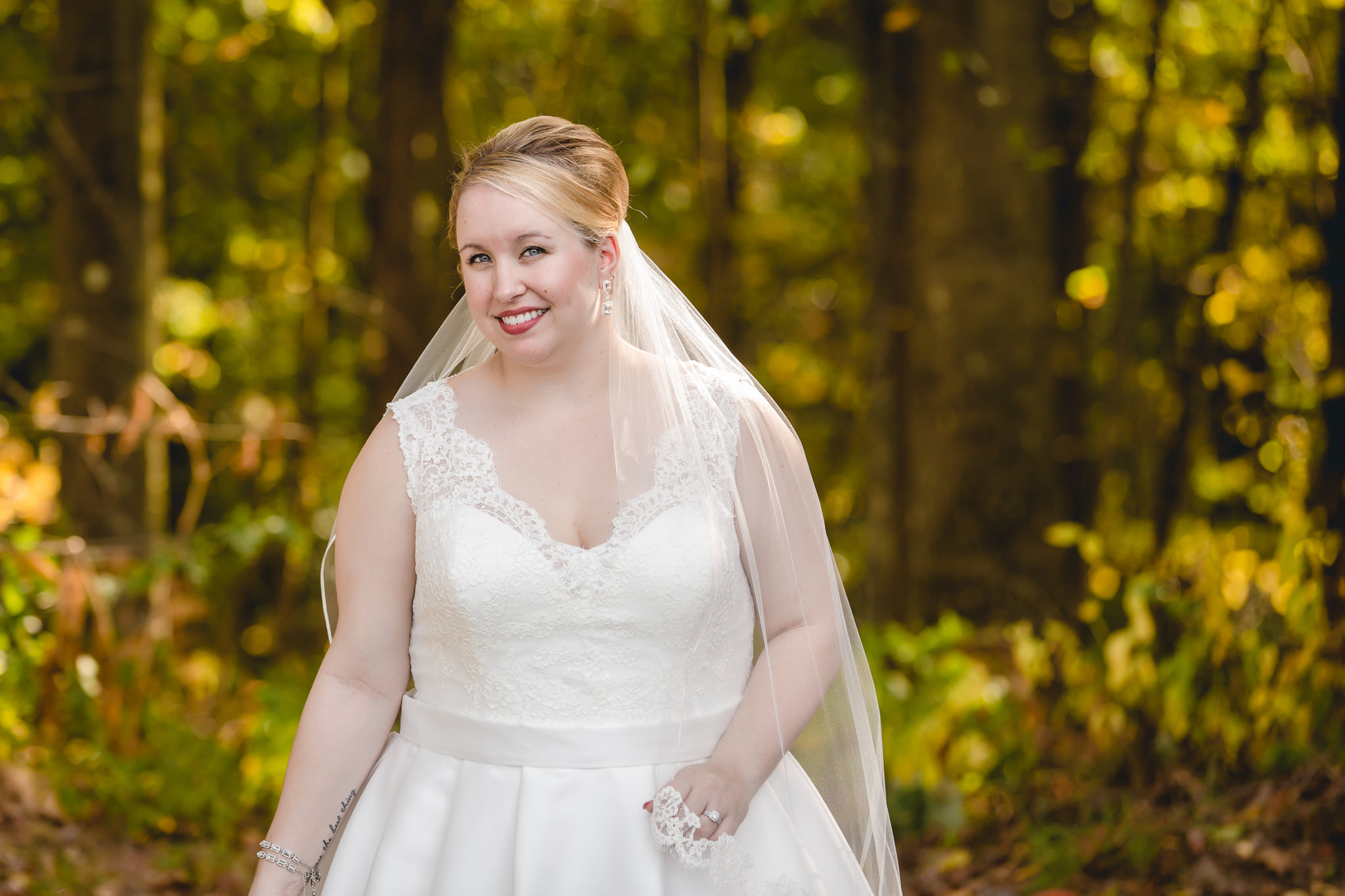 Bride smiles as sun shines through her veil at the Barn at Soergel Hollow