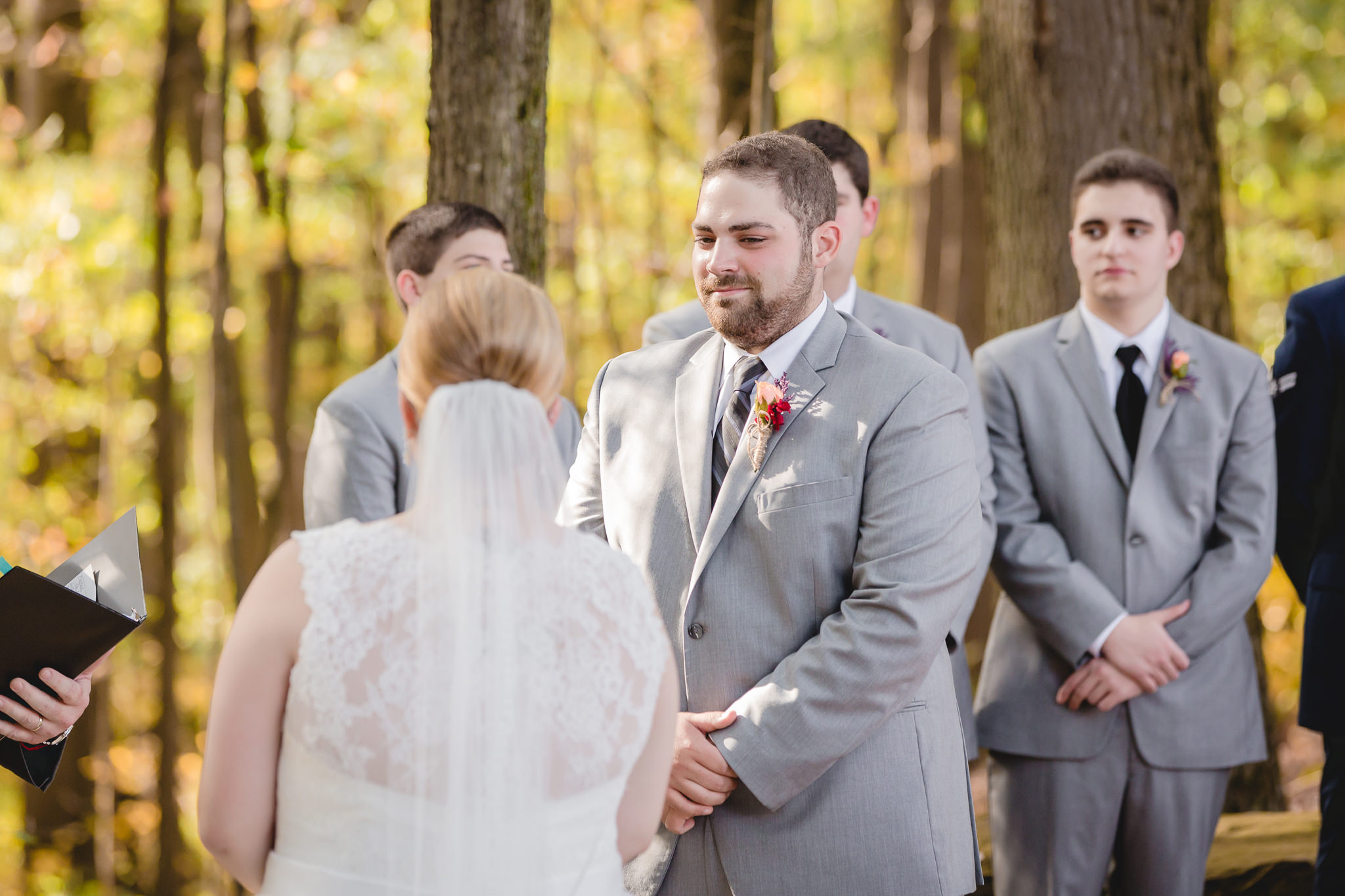 Groom smiles at his bride at their Barn at Soergel Hollow wedding ceremony