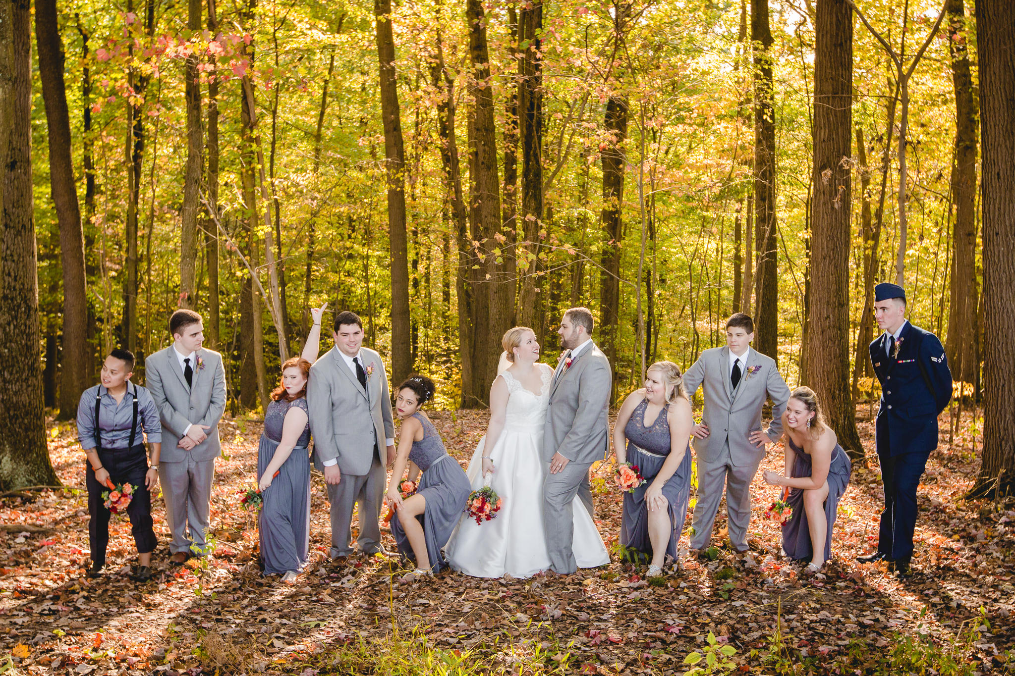 Bridal party takes a silly picture in the woods at the Barn at Soergel Hollow