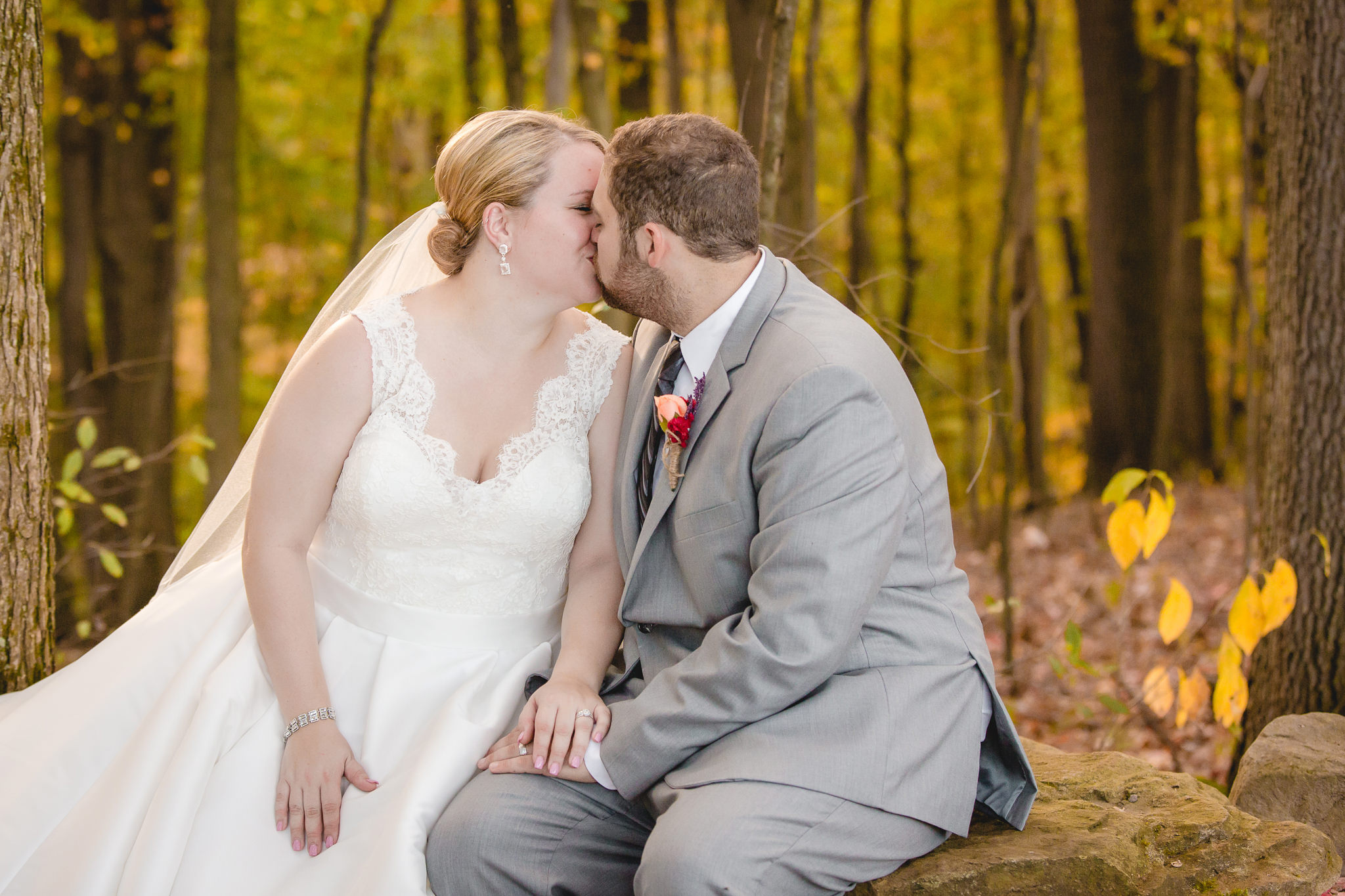 Newlyweds share a kiss in the woods at the Barn at Soergel Hollow