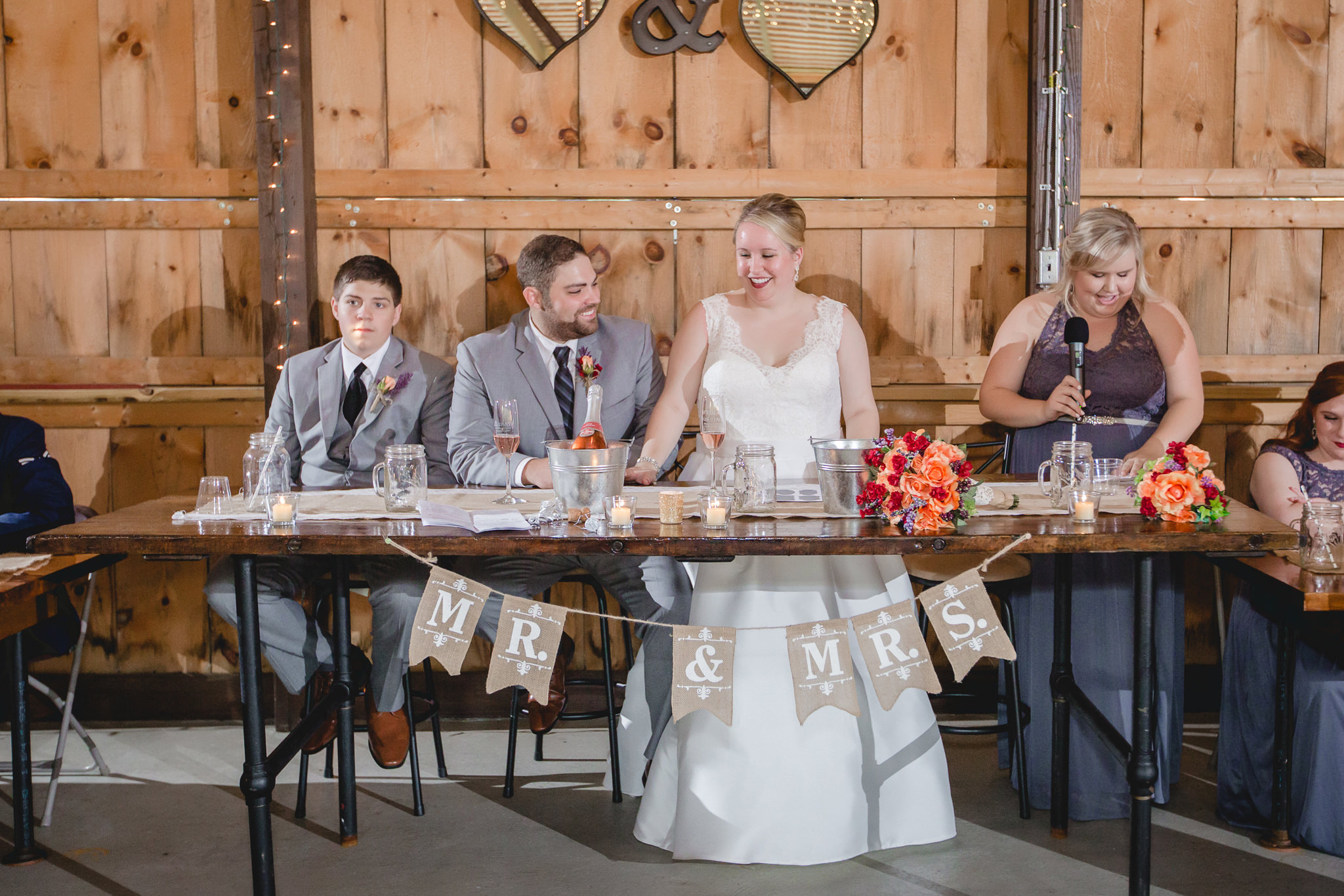 Bride and groom laugh during toasts at their Barn at Soergel Hollow wedding reception