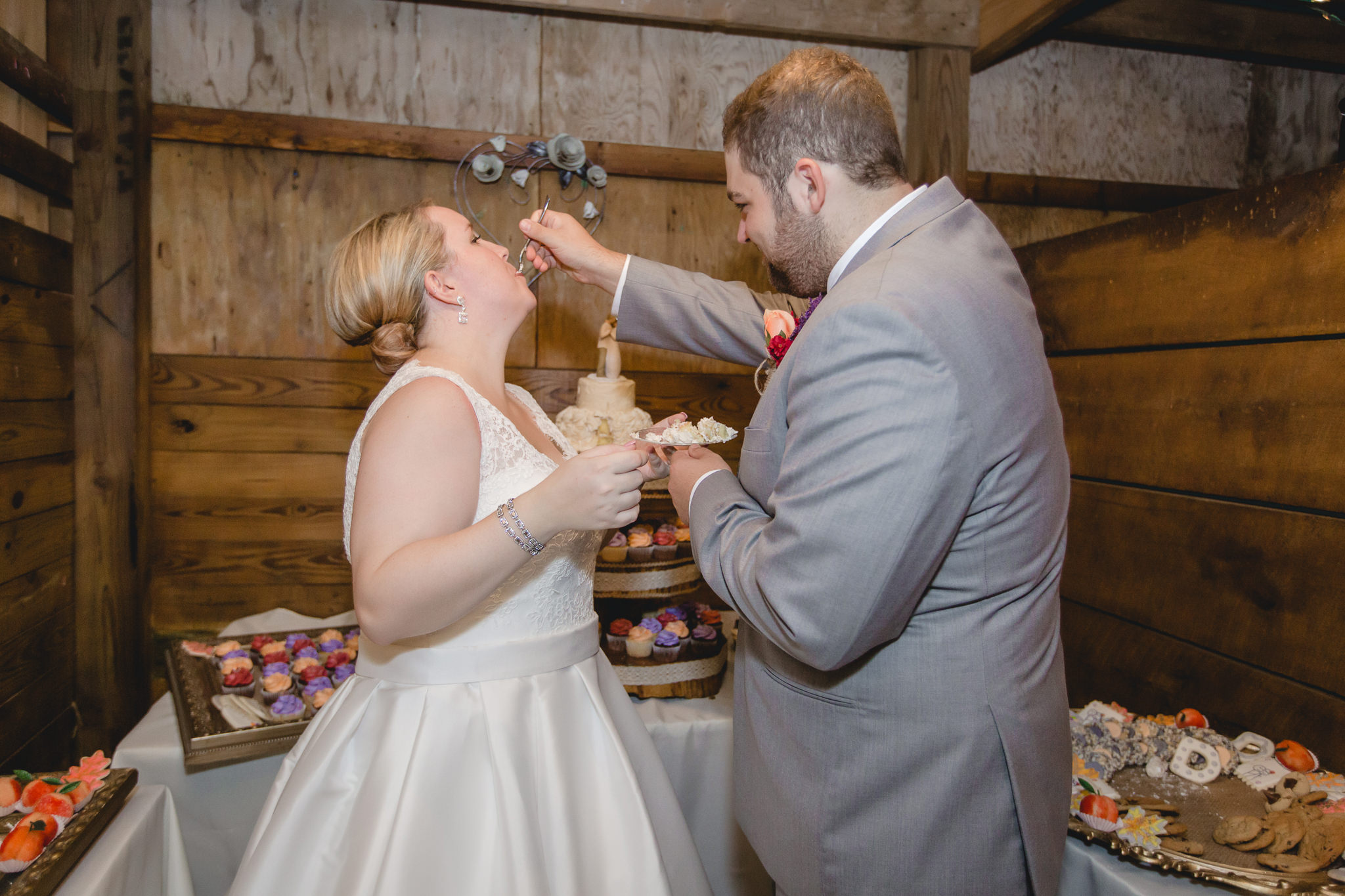 Groom feeds the bride a piece of cake at the Barn at Soergel Hollow