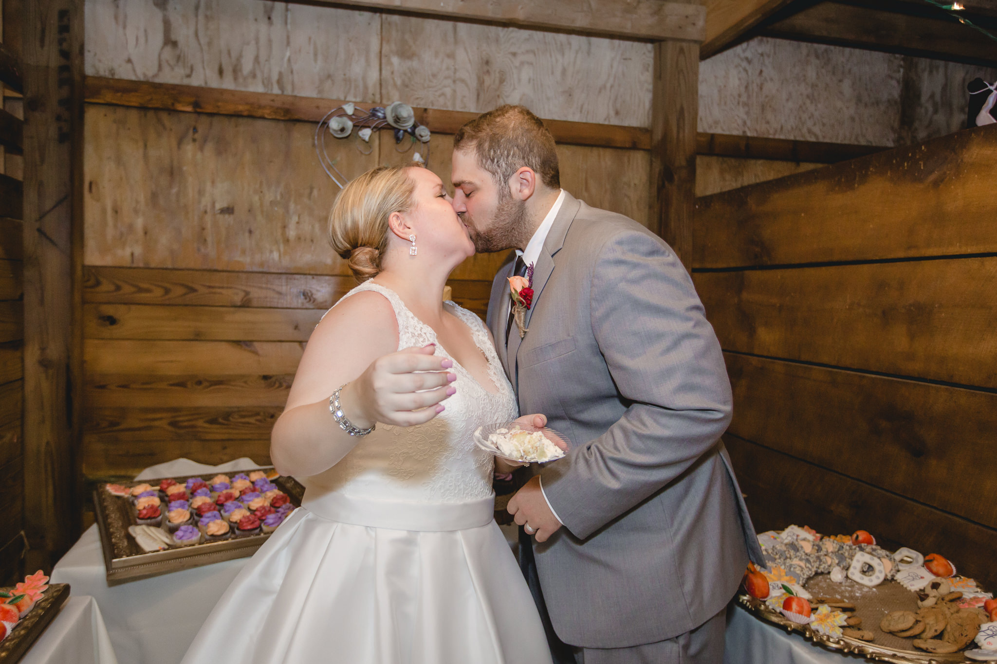 Bride and groom kiss after their cake cutting at the Barn at Soergel Hollow