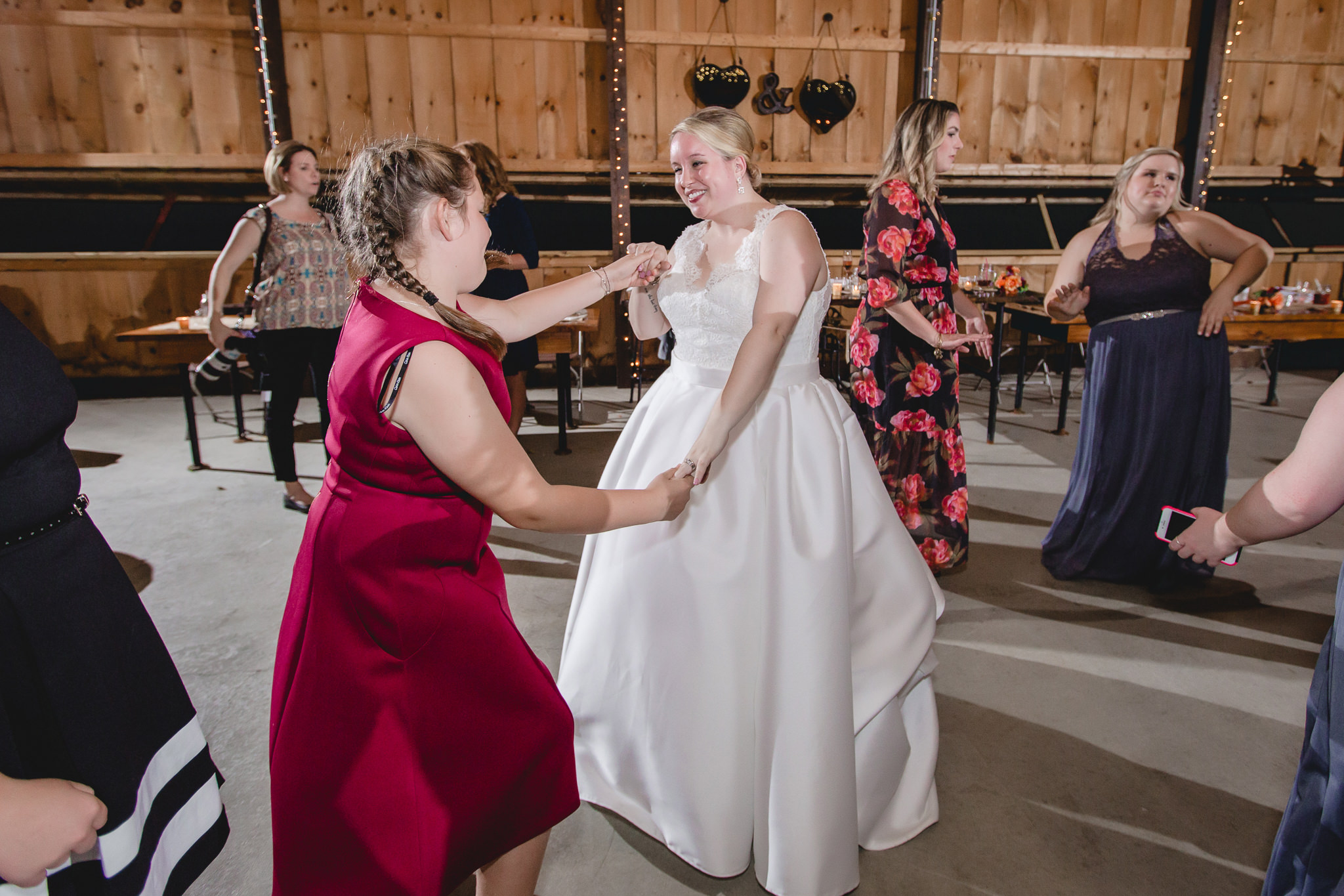 Bride dances with a wedding guest at her Barn at Soergel Hollow wedding