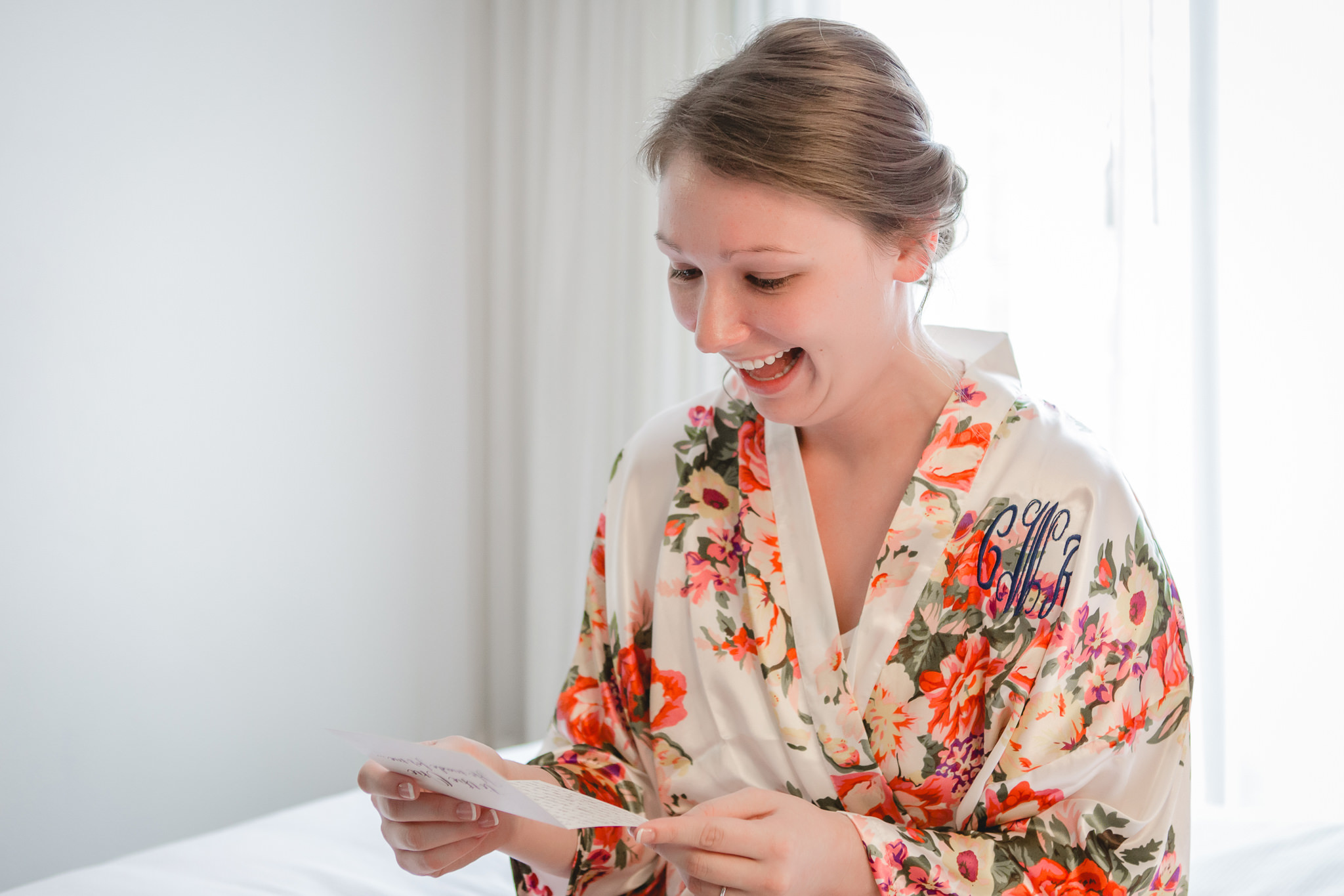 Bride laughs as she reads a note from her groom