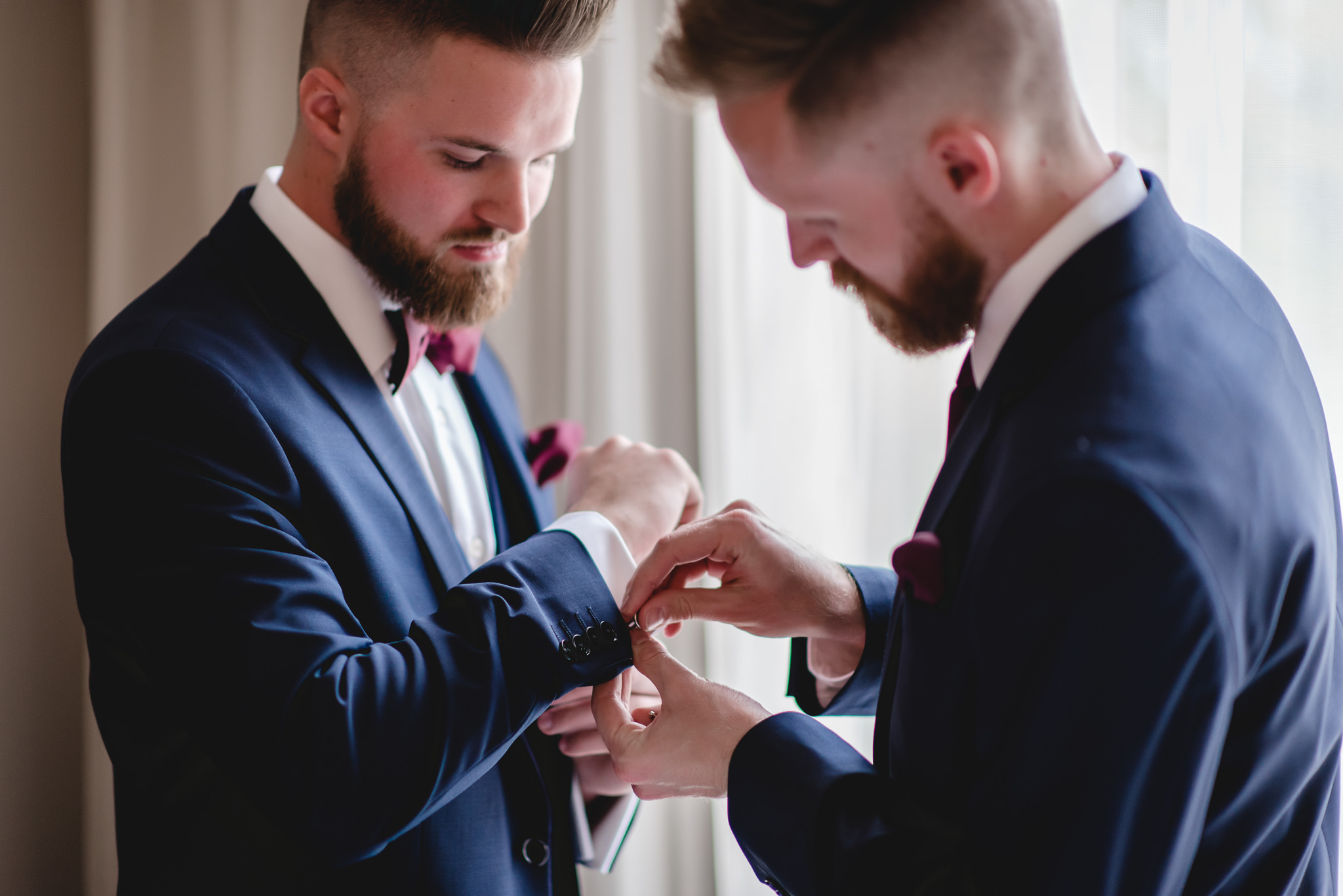 Best man helps the groom with his cufflinks before his wedding at the Chadwick