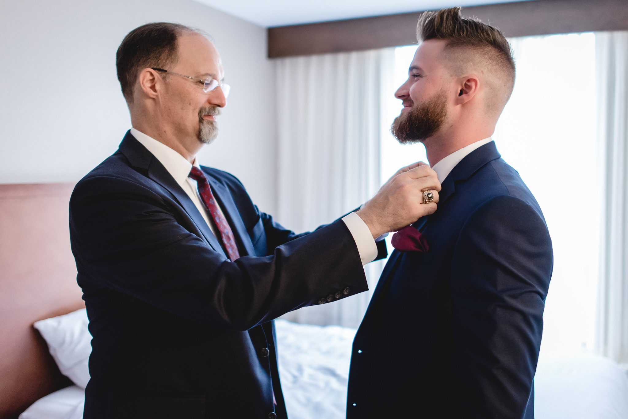 Father of the groom straightens the groom's bowtie