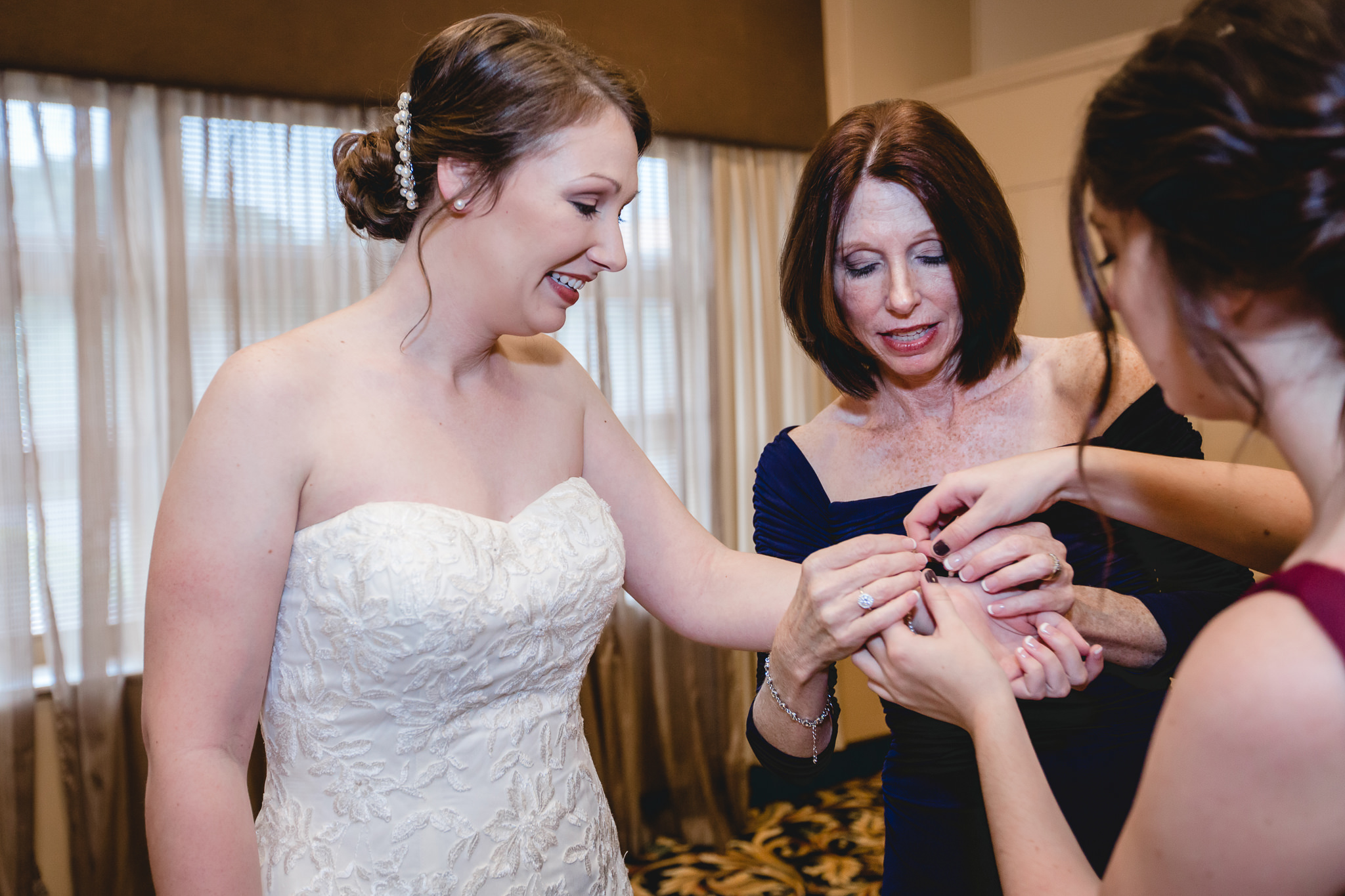 Mother of the bride puts the bride's bracelet on at the Chadwick
