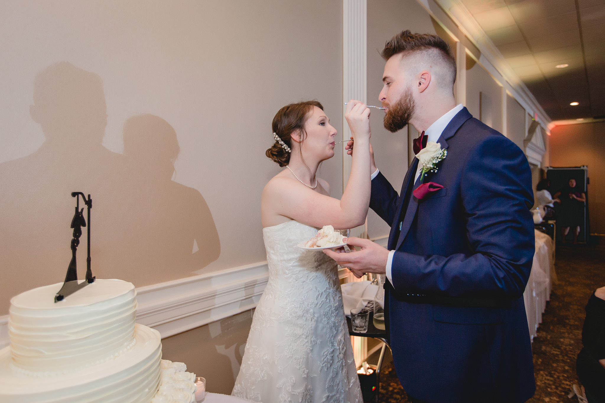 Bride and groom feed each other cake at their Chadwick wedding reception