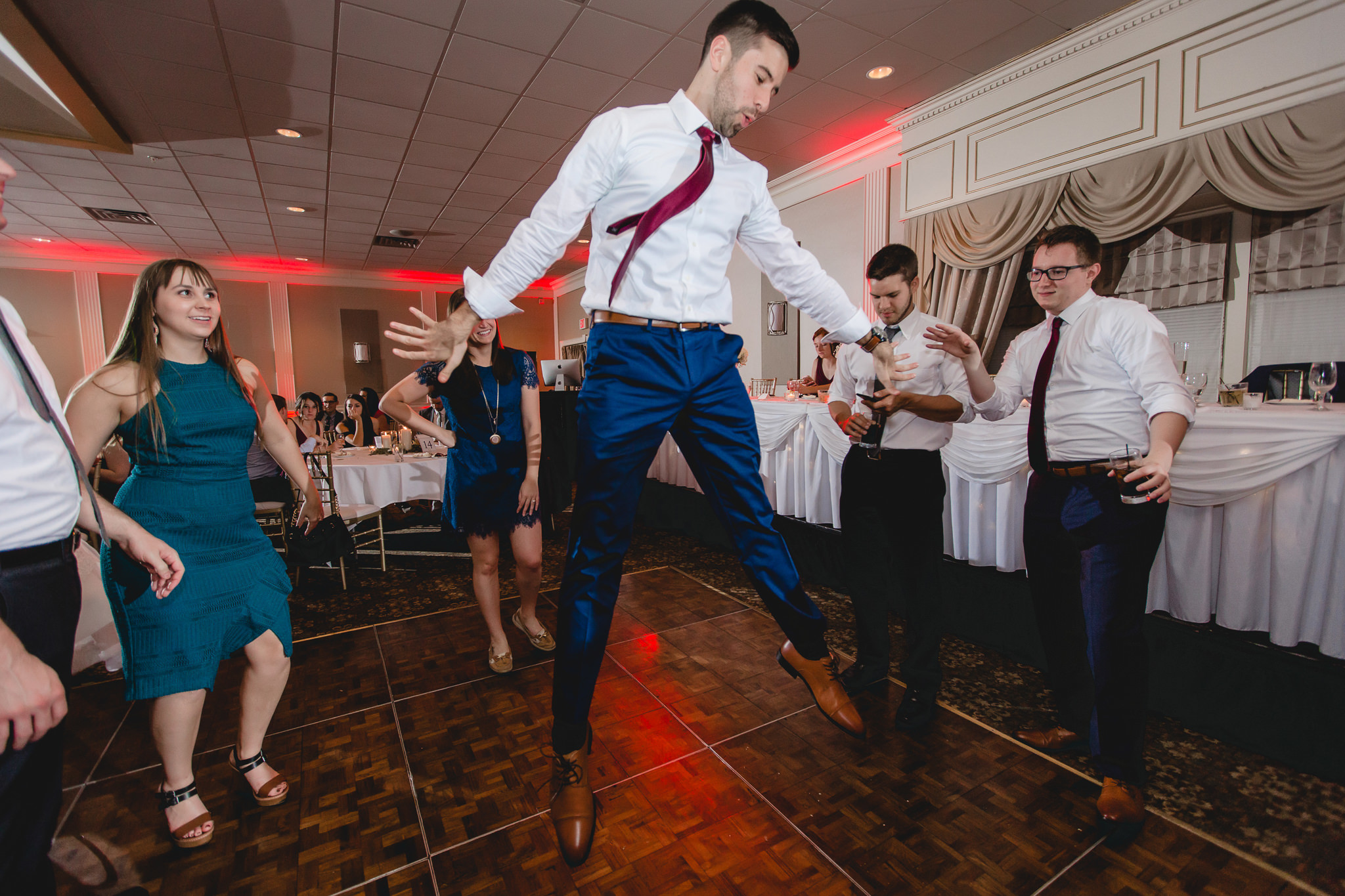 Groomsman hangs midair while dancing at a Chadwick wedding reception
