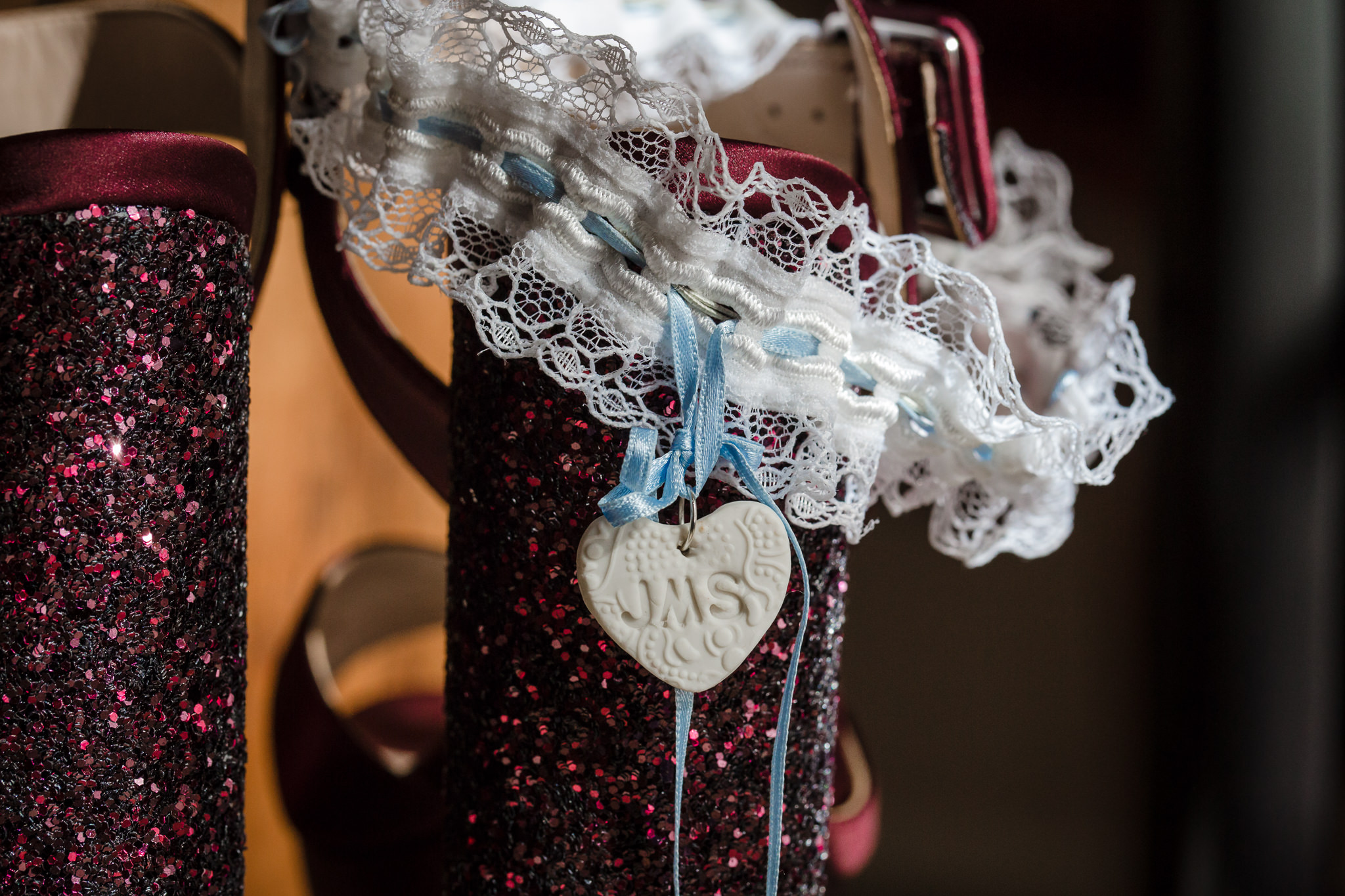 Personalized token hangs from bride's white garter