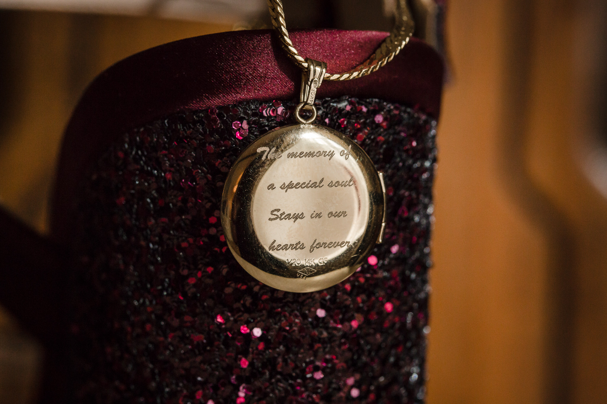Memory locket for bride's father hangs from her wedding shoes