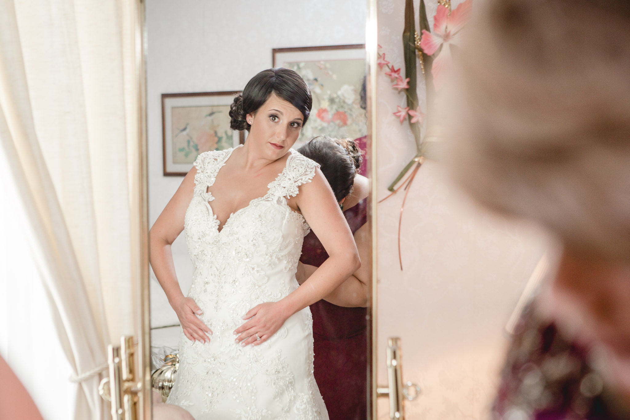 Bride checks herself in a mirror before her wedding at the DoubleTree Pittsburgh Airport