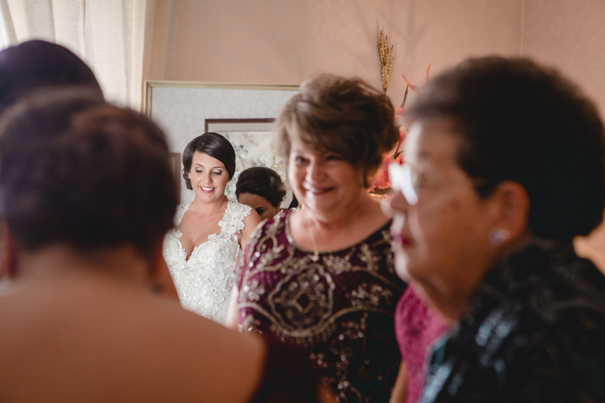 Mother of the bride looks at her daughter while she dresses for her wedding