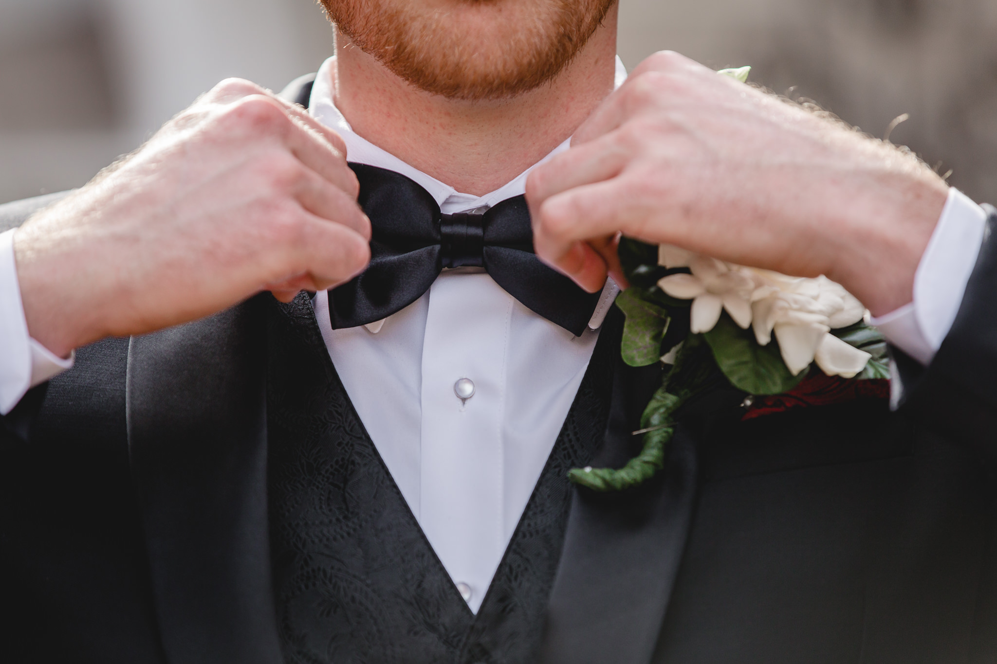 Groom straightens his bowtie before his wedding at St. John the Baptist in Monaca