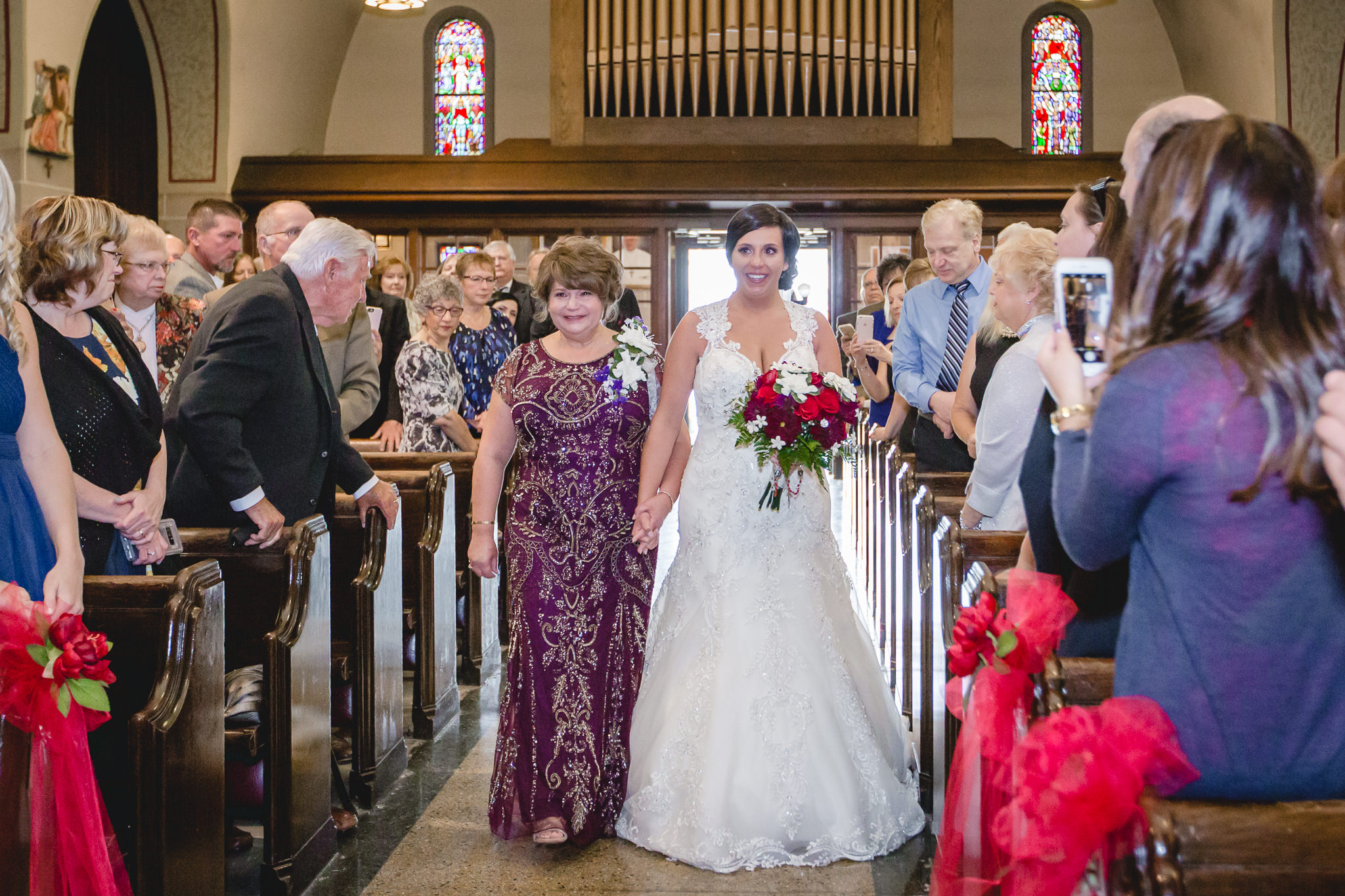 Mother of the bride walks her daughter down the aisle at St. John the Baptist