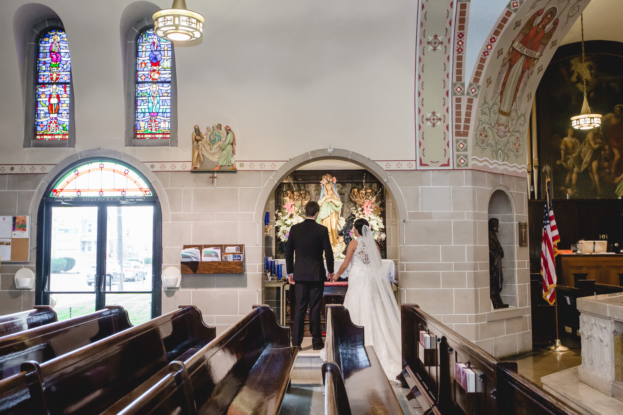 Bride and groom take roses to Mary at St. John the Baptist