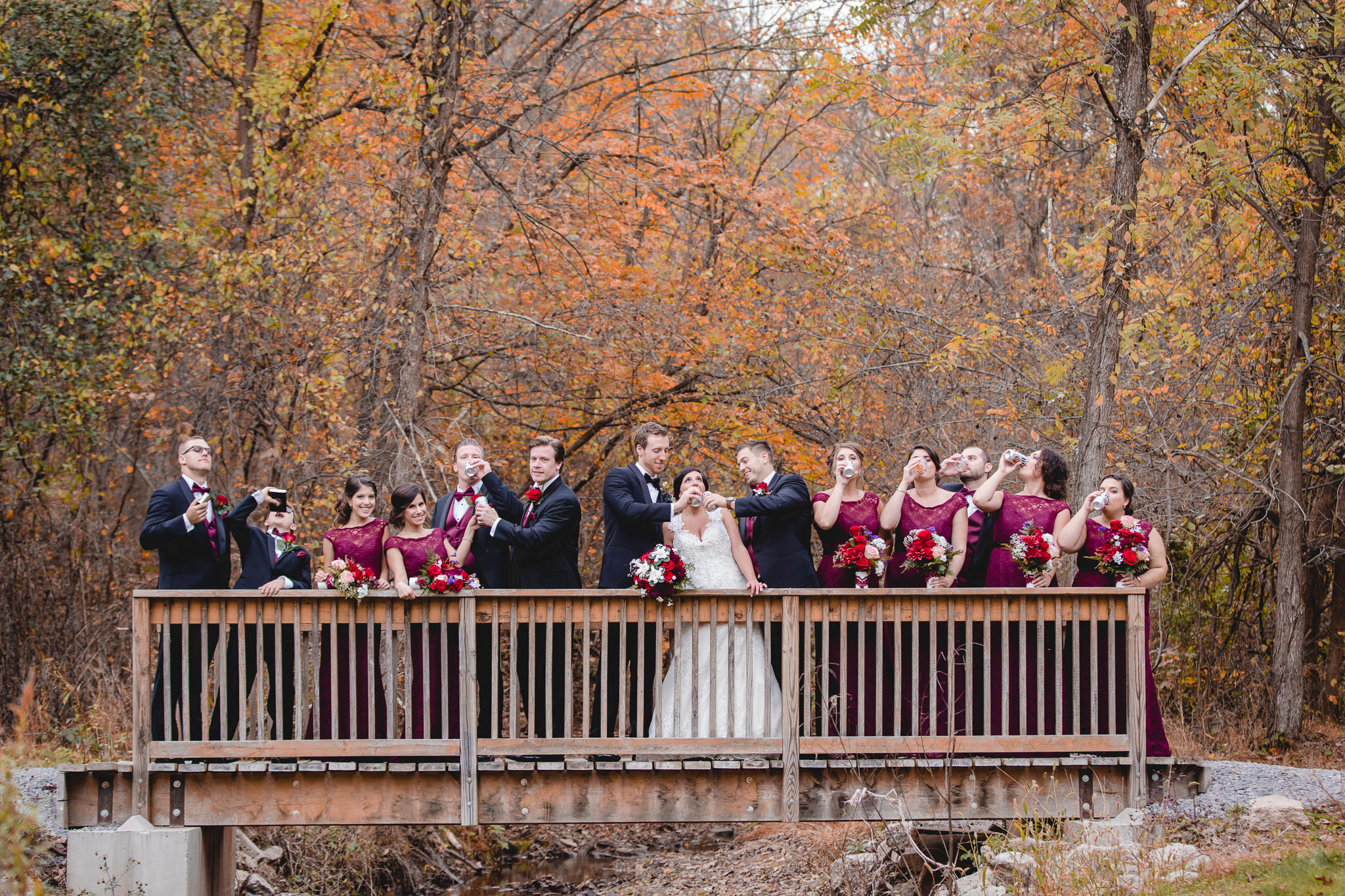 Bridal party takes a silly drinking shot on a bridge in Moon Township for an October wedding at DoubleTree Pittsburgh Airport