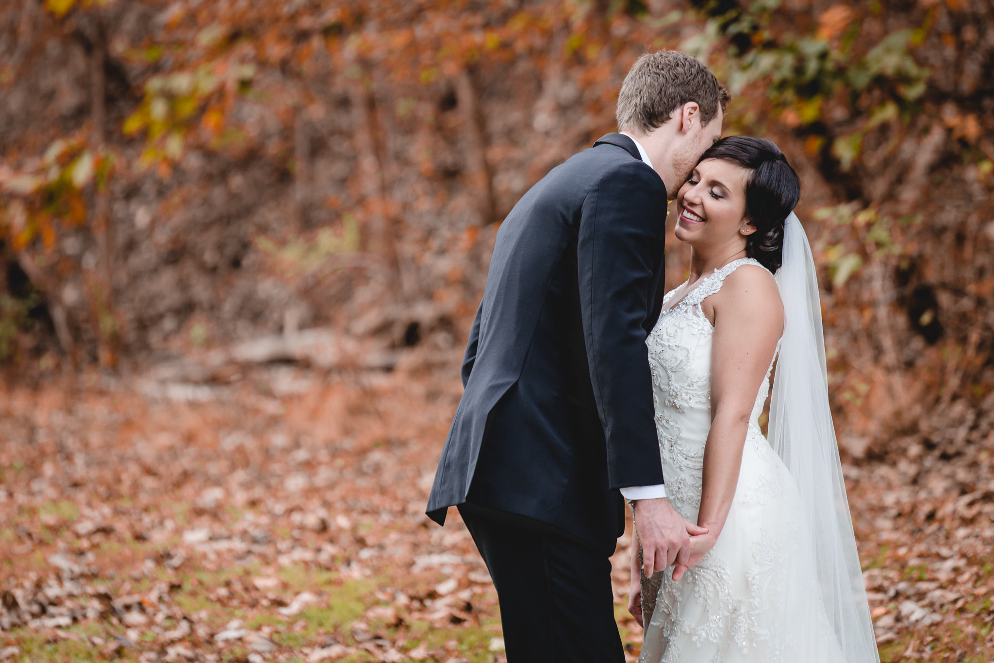 Groom makes his bride laugh in fall foliage before their DoubleTree Pittsburgh Airport wedding reception