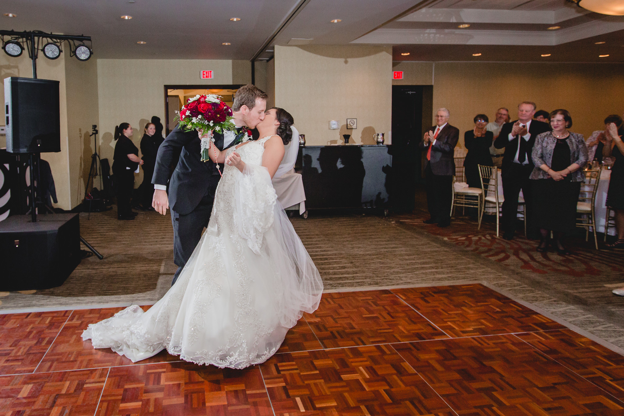 Groom kisses his bride as they enter their DoubleTree Pittsburgh Airport reception