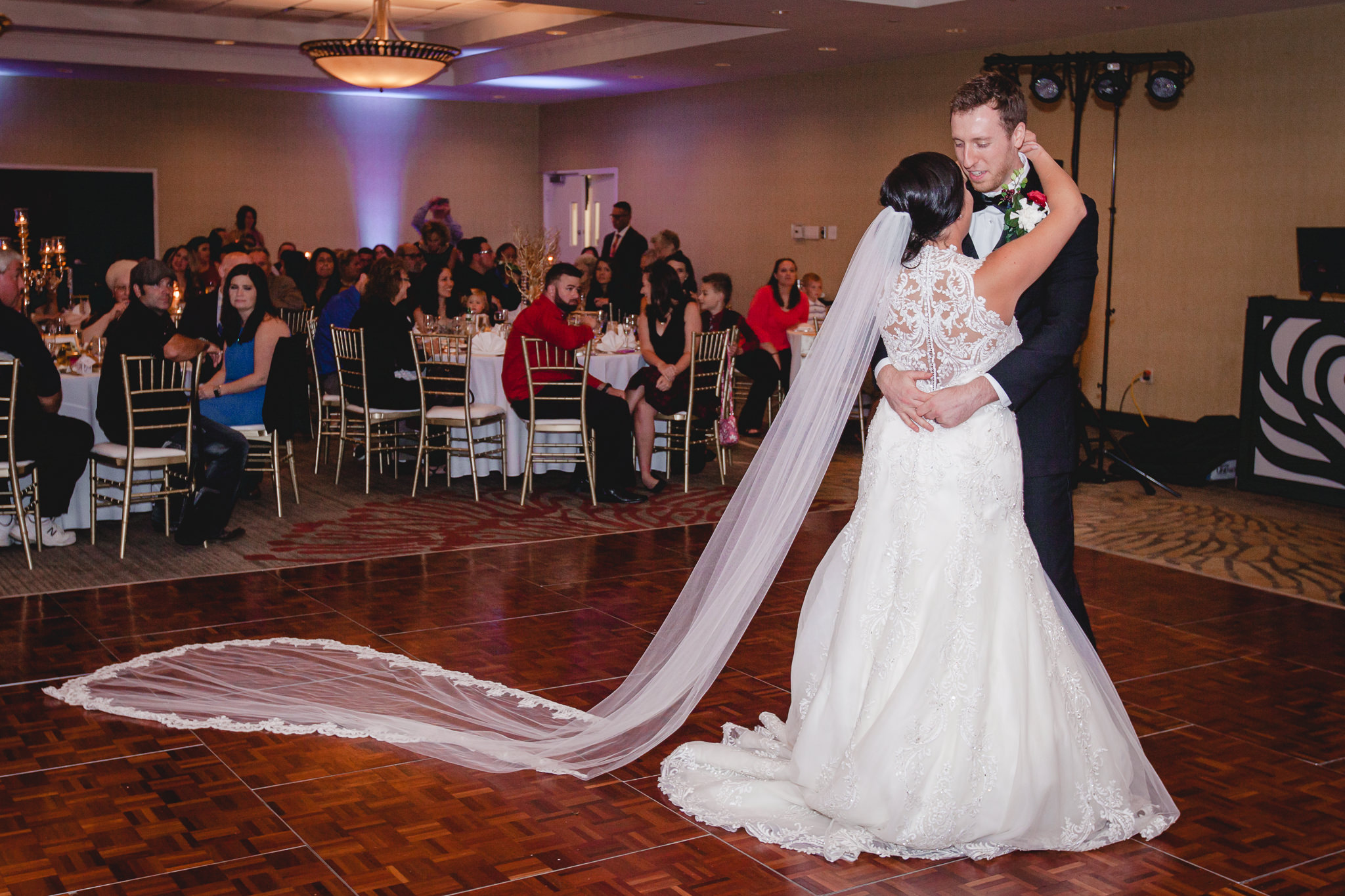 Bride and groom's first dance at DoubleTree Pittsburgh Airport with cathedral veil spread out