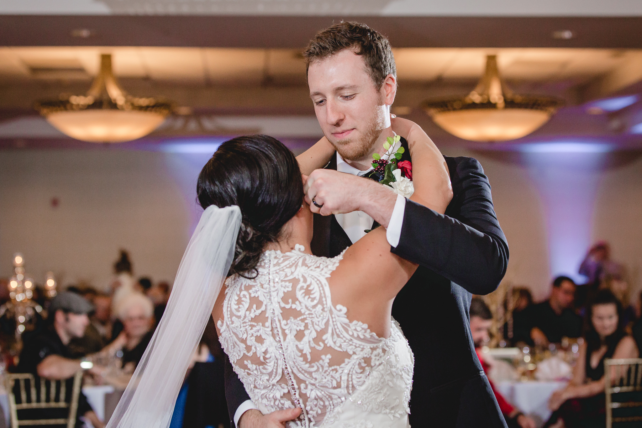 Groom wipes a tear from bride's eyes as they dance at DoubleTree Pittsburgh Airport