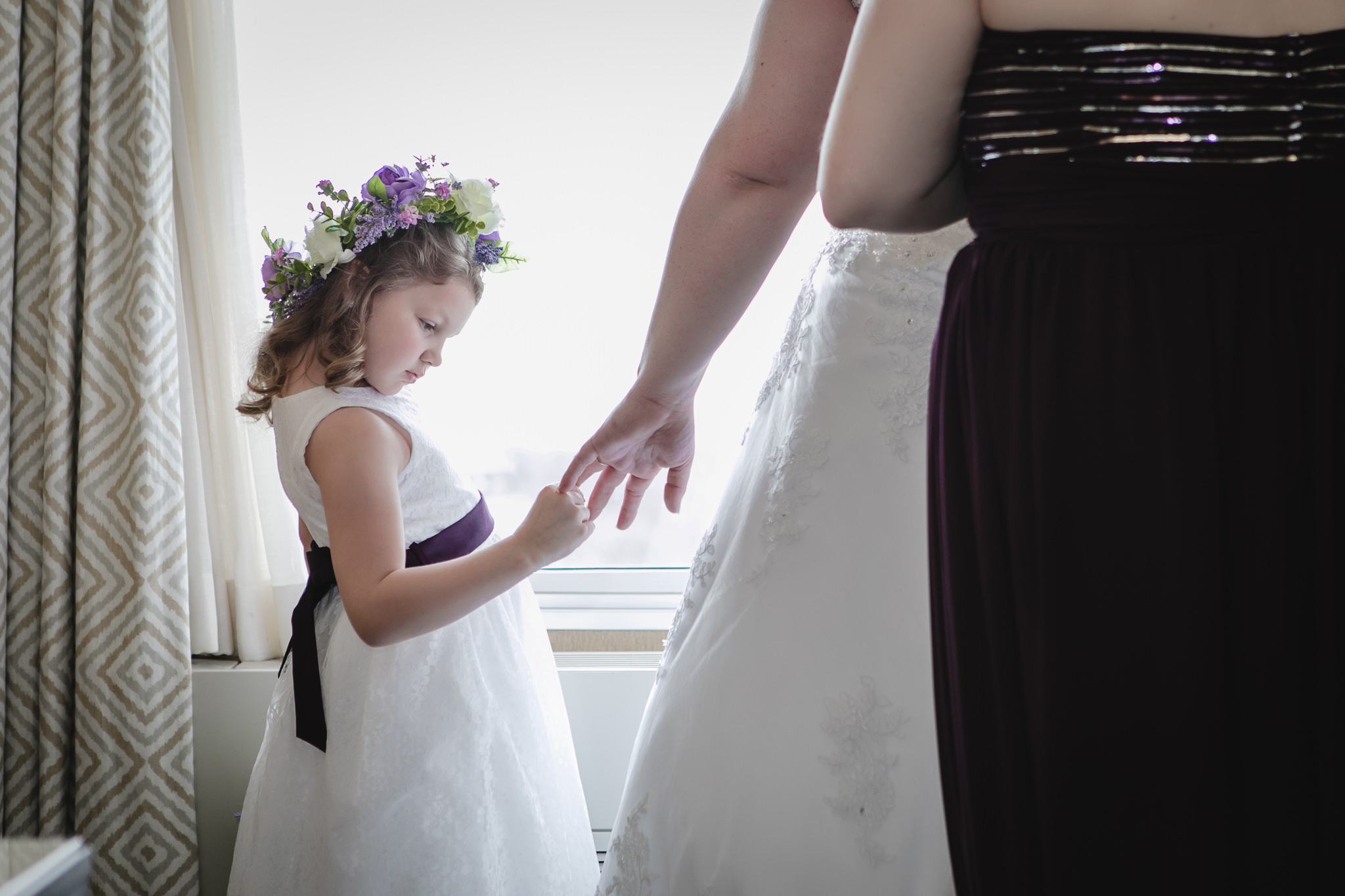 Flower girl looks at bride's engagement ring on her wedding day