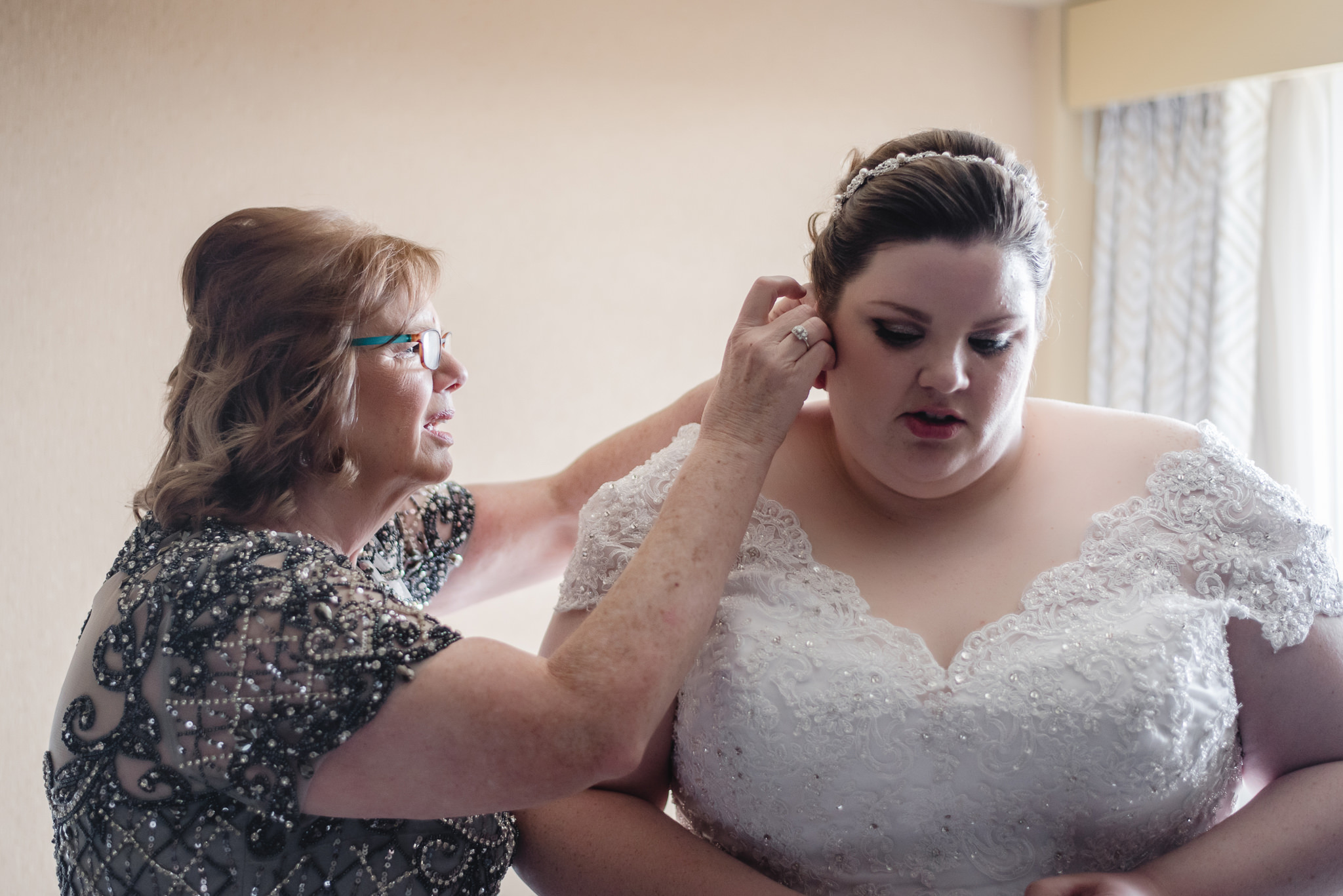 Mother of the bride helps bride with her jewelry