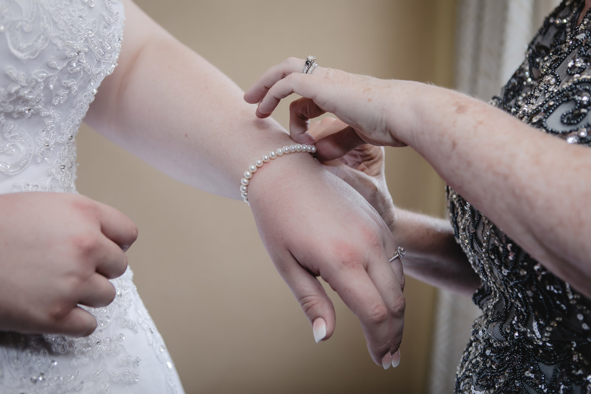 Mother of the Bride puts on bride's pearl bracelet
