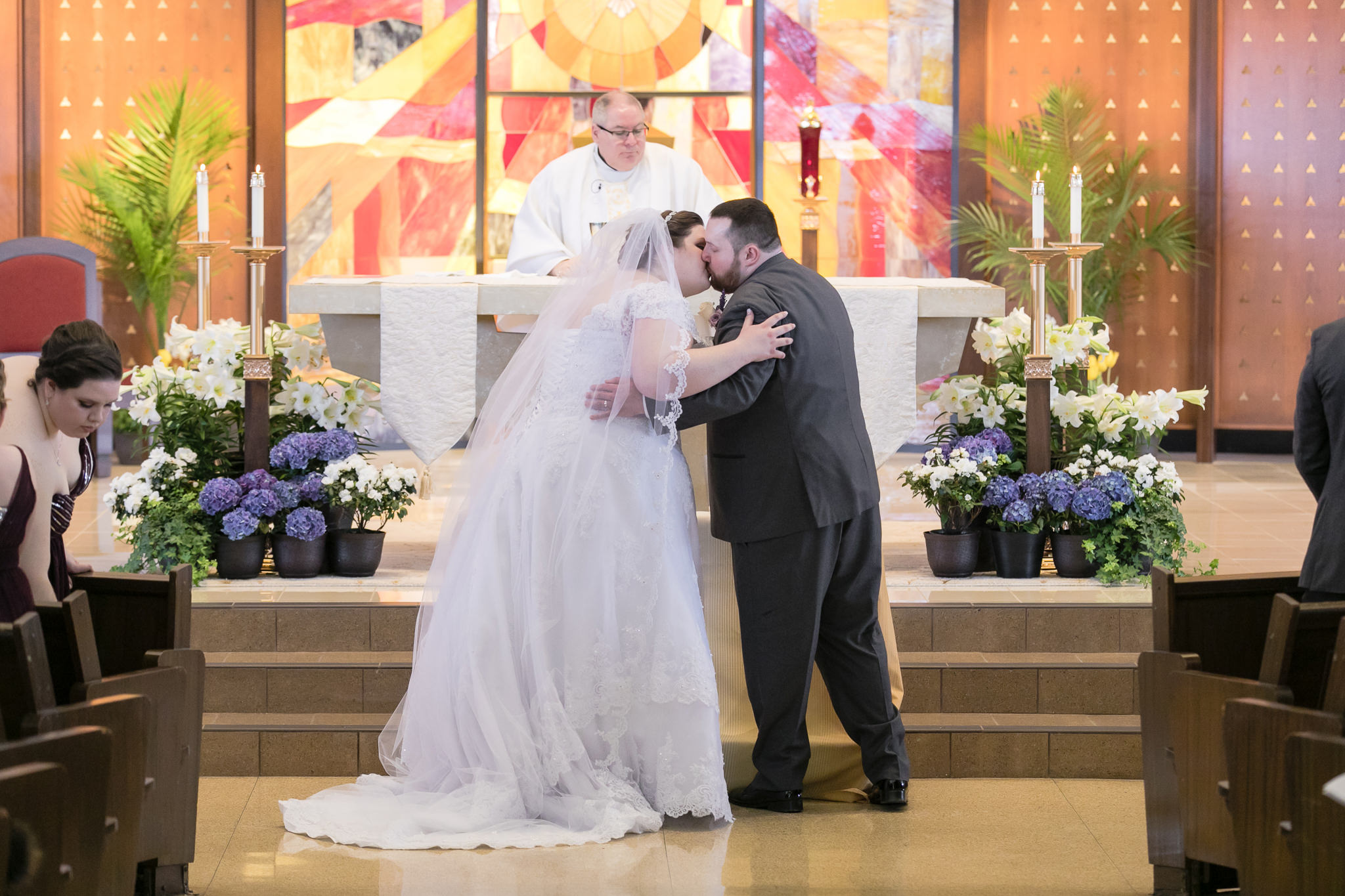 Bride & groom share a kiss during their wedding ceremony at Holy Trinity in Robinson Township