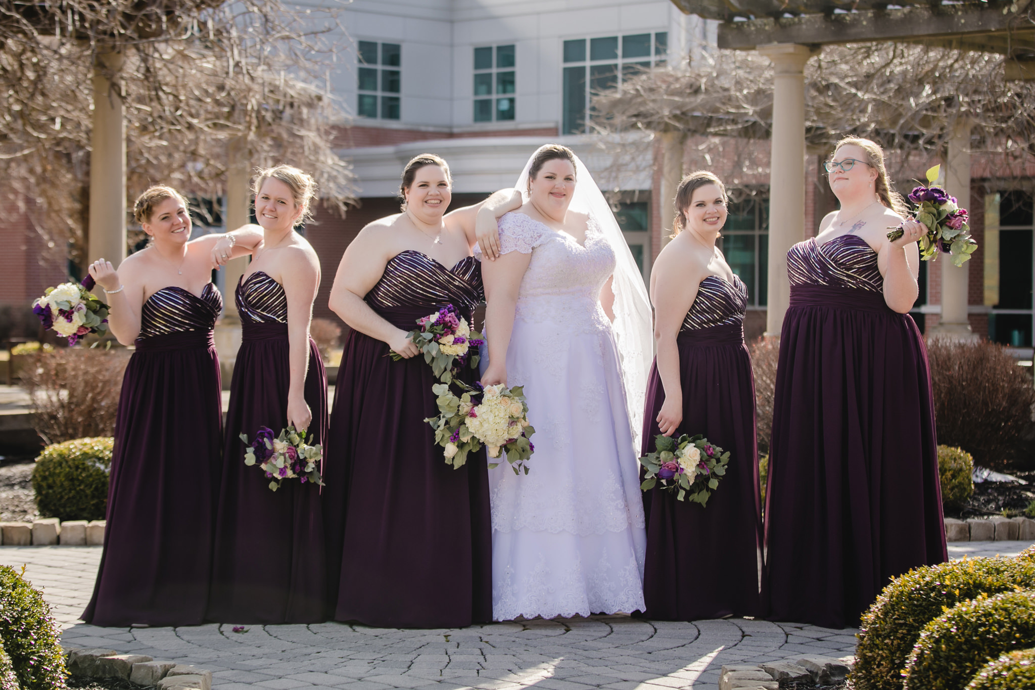 Bridesmaids strike a pose near Massey Hall at Robert Morris University