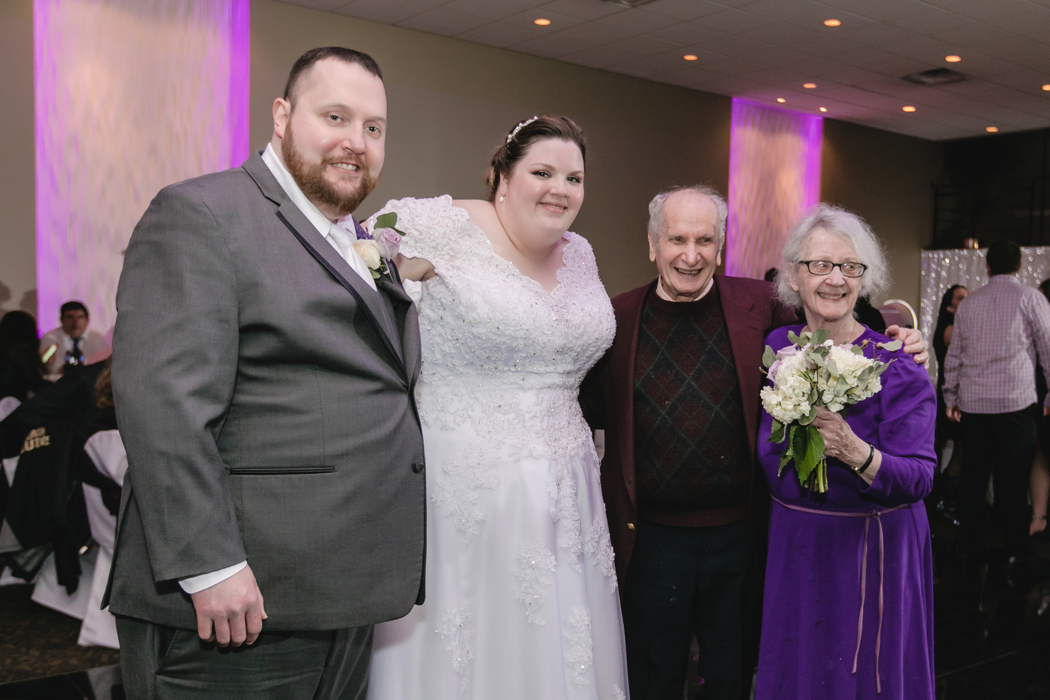 Newlyweds pose with longest married couple at their wedding reception at the Fez