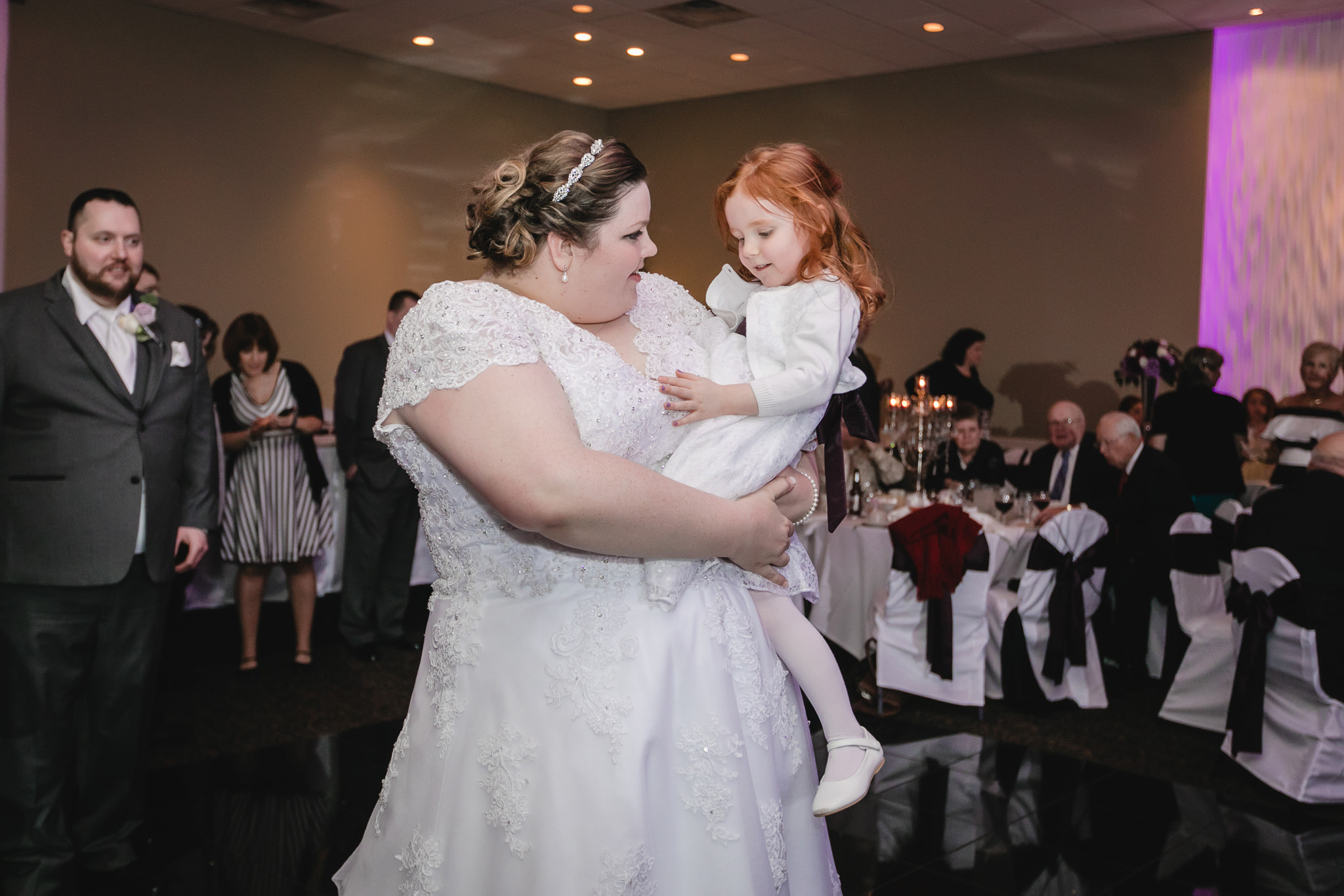 Bride holds the flower girl at her Fez wedding reception
