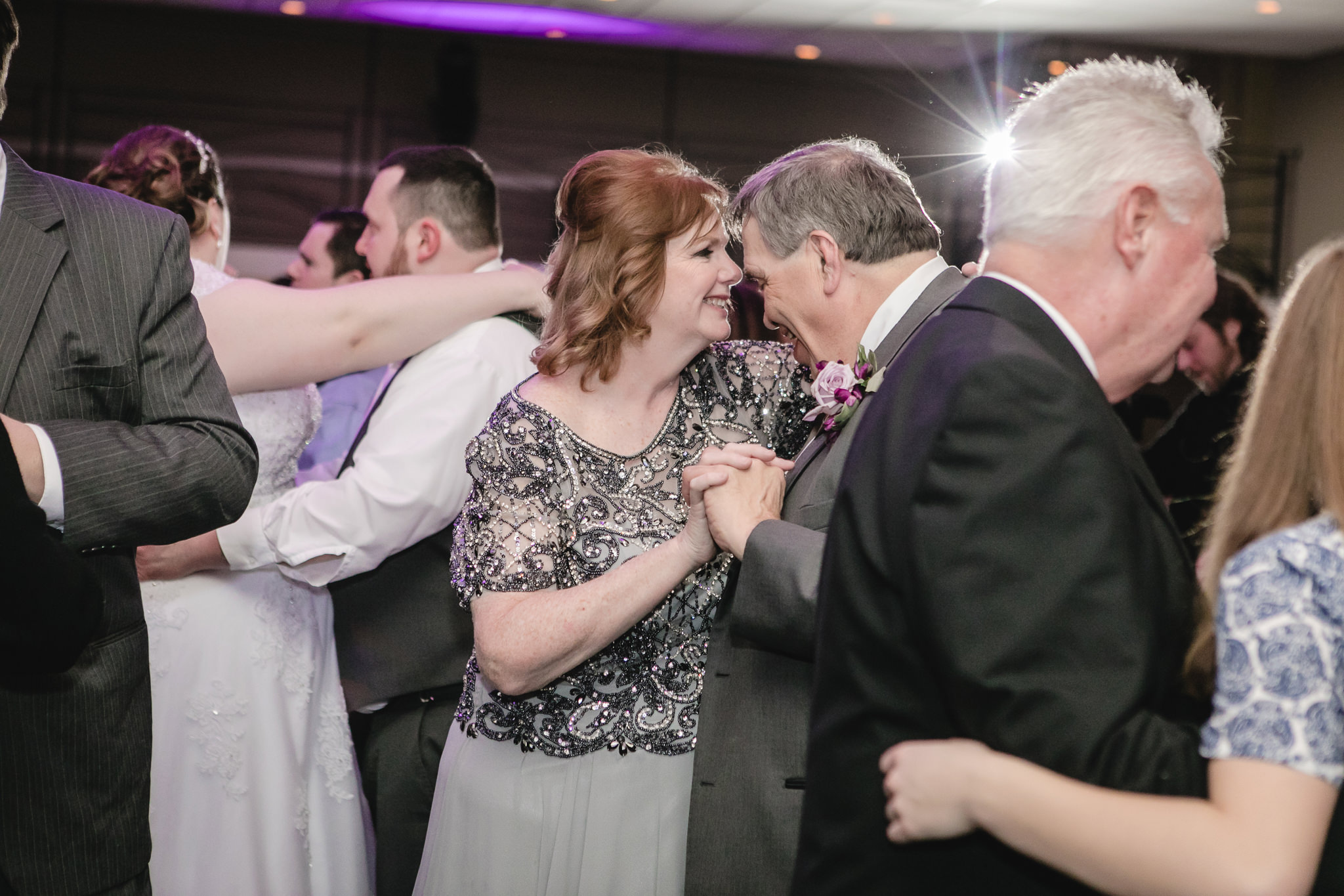 Parents of the bride laugh together while dancing at the Fez