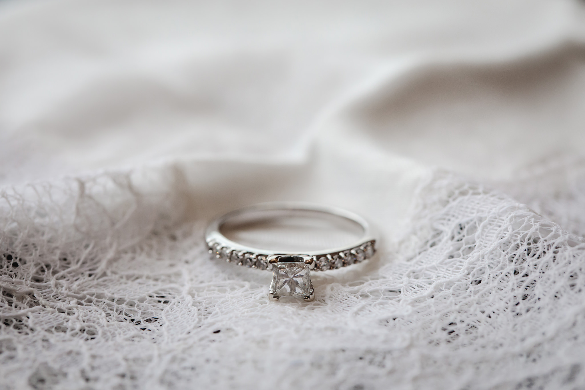 Solitary diamond engagement ring rests on a white handkerchief