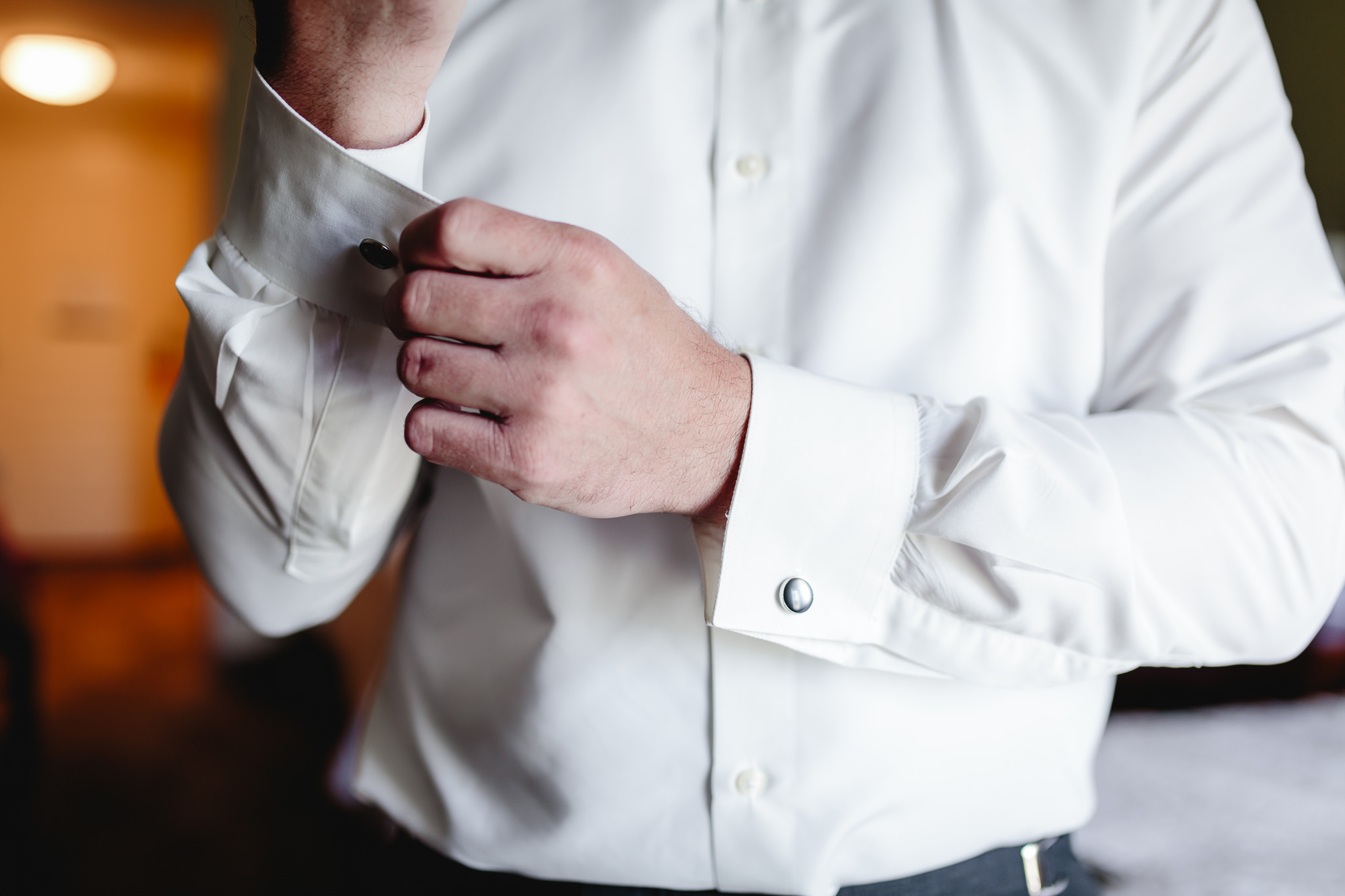 Groom fastens his cuff links at Chestnut Ridge Golf Resort