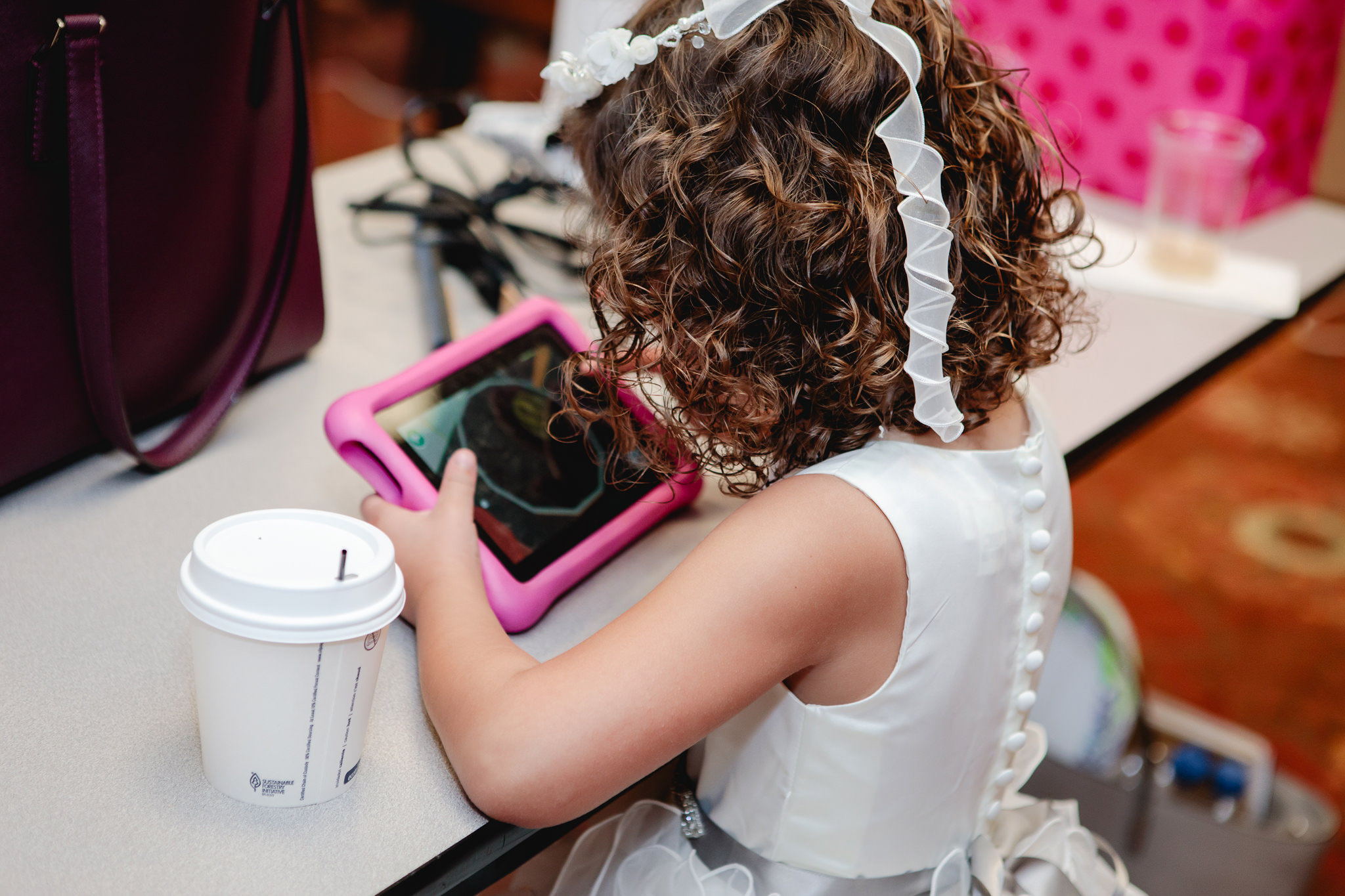 Flower girl plays on her iPad waiting for the ceremony to begin at Chestnut Ridge Golf Resort