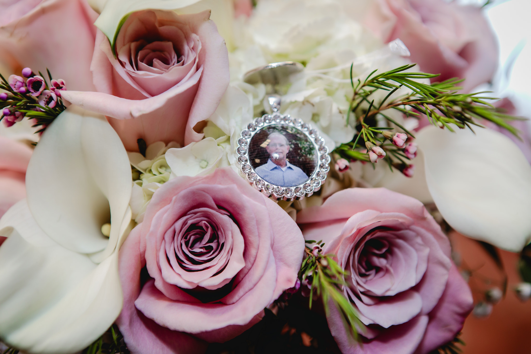 Photo of bride's late father hangs from her bouquet of roses and lilies