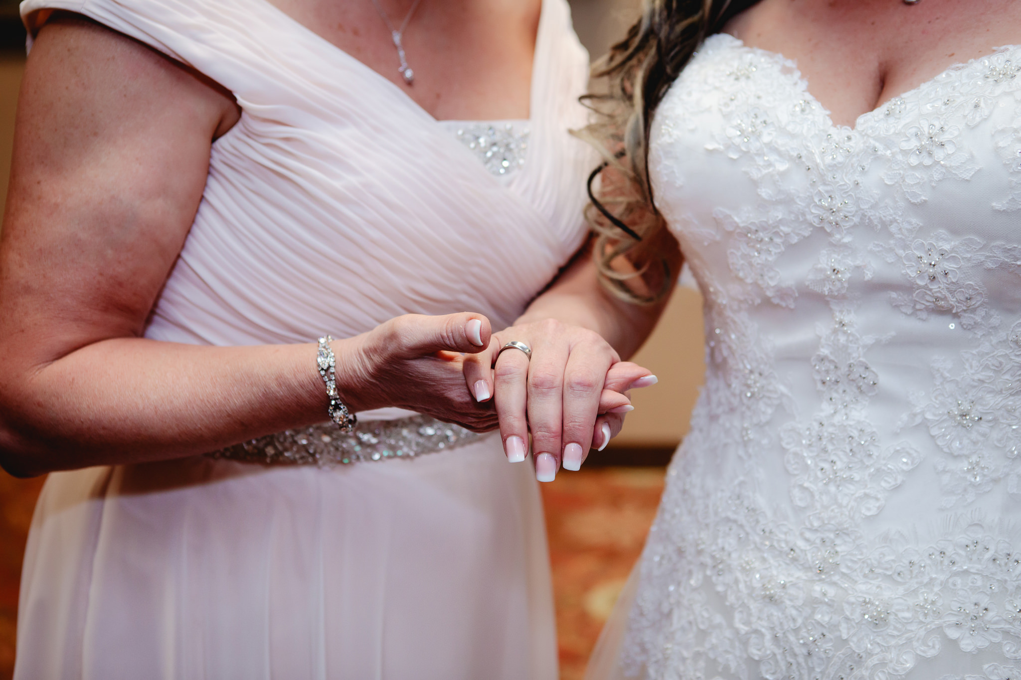 Mother of the bride looks at bride's ring